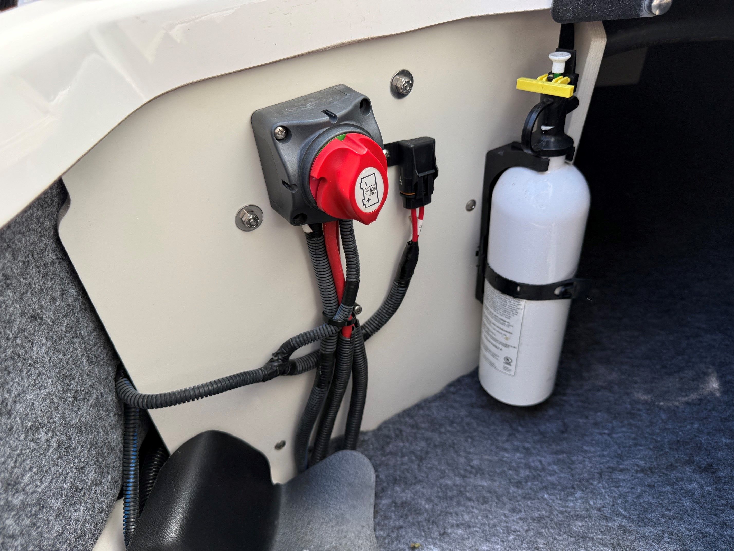 A boat interior with a fire extinguisher and electrical connections visible.