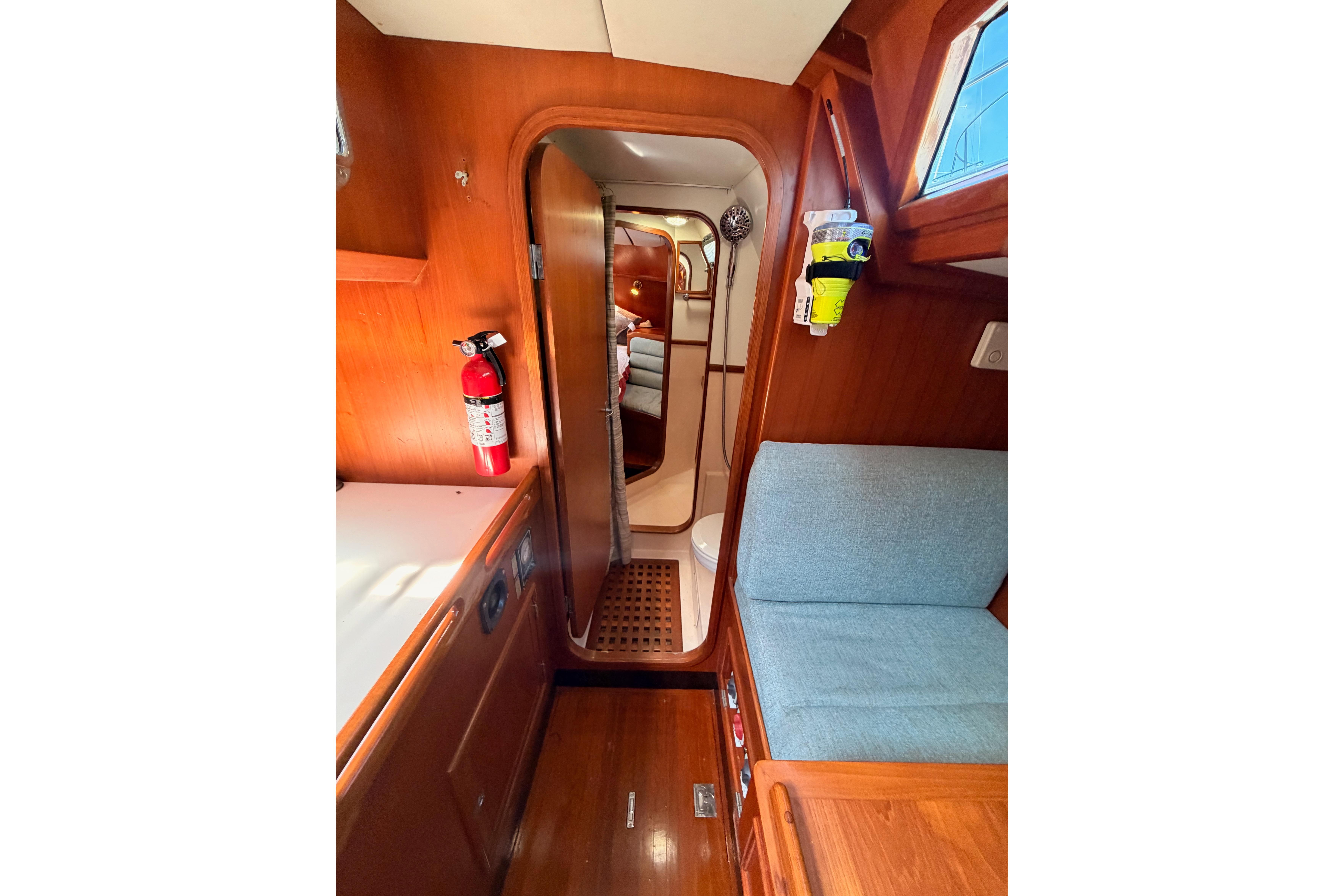 Interior of 1991 Hylas 51 yacht with wooden finish and cozy seating area.