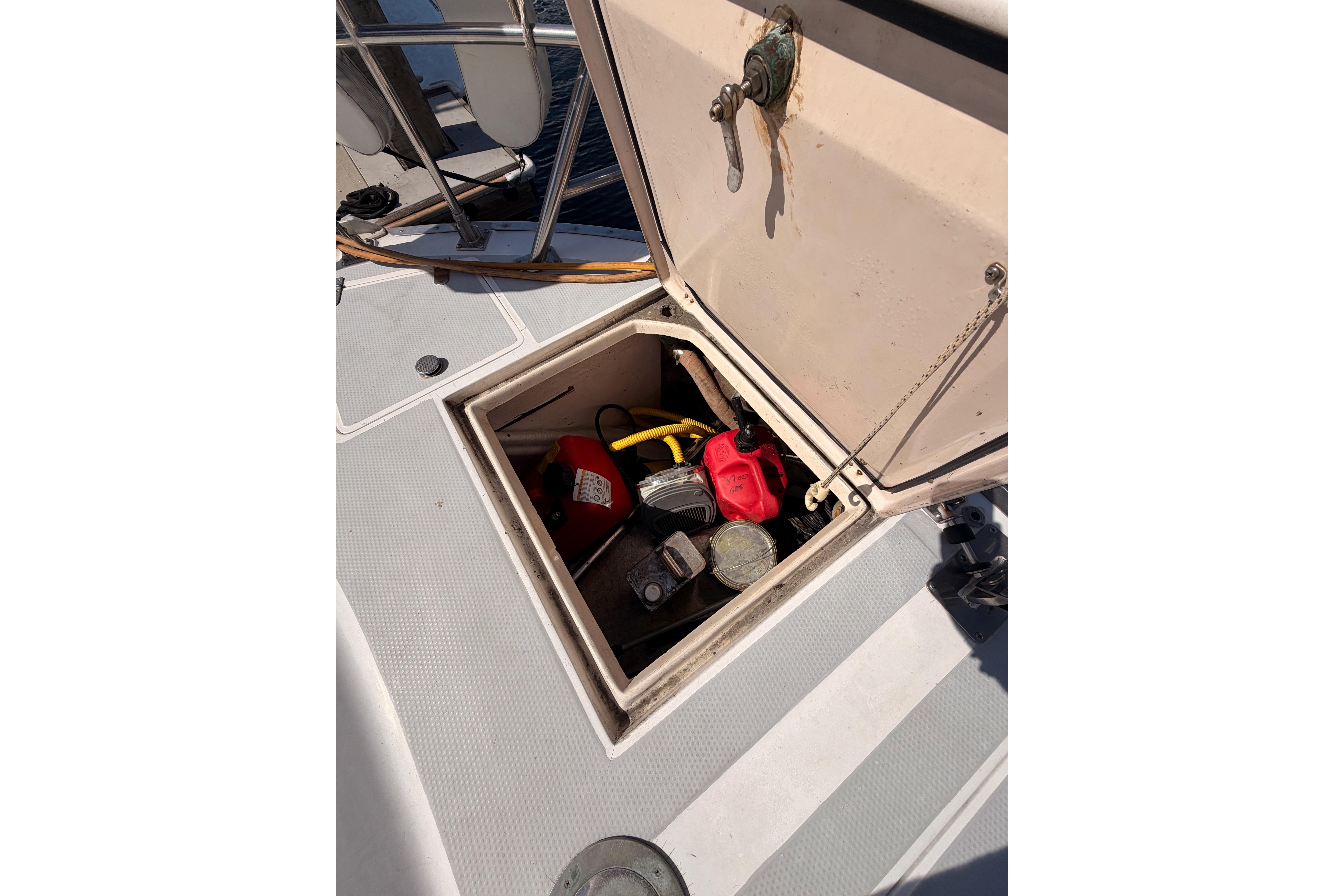 Open storage compartment on 1991 Hylas 51 yacht deck, containing various tools and equipment.