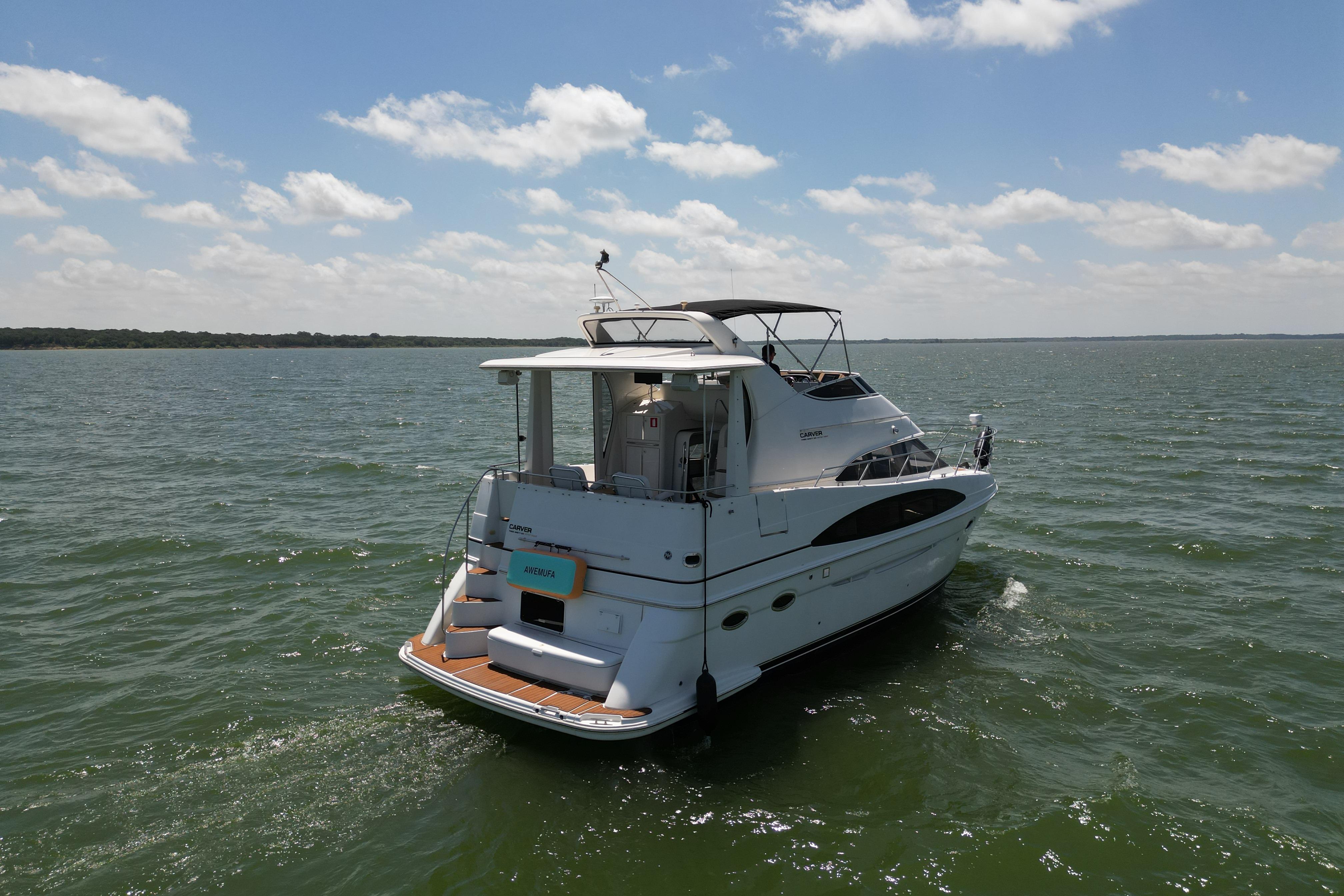 2002 Carver 396 Motor Yacht cruising on open water under a partly cloudy sky.