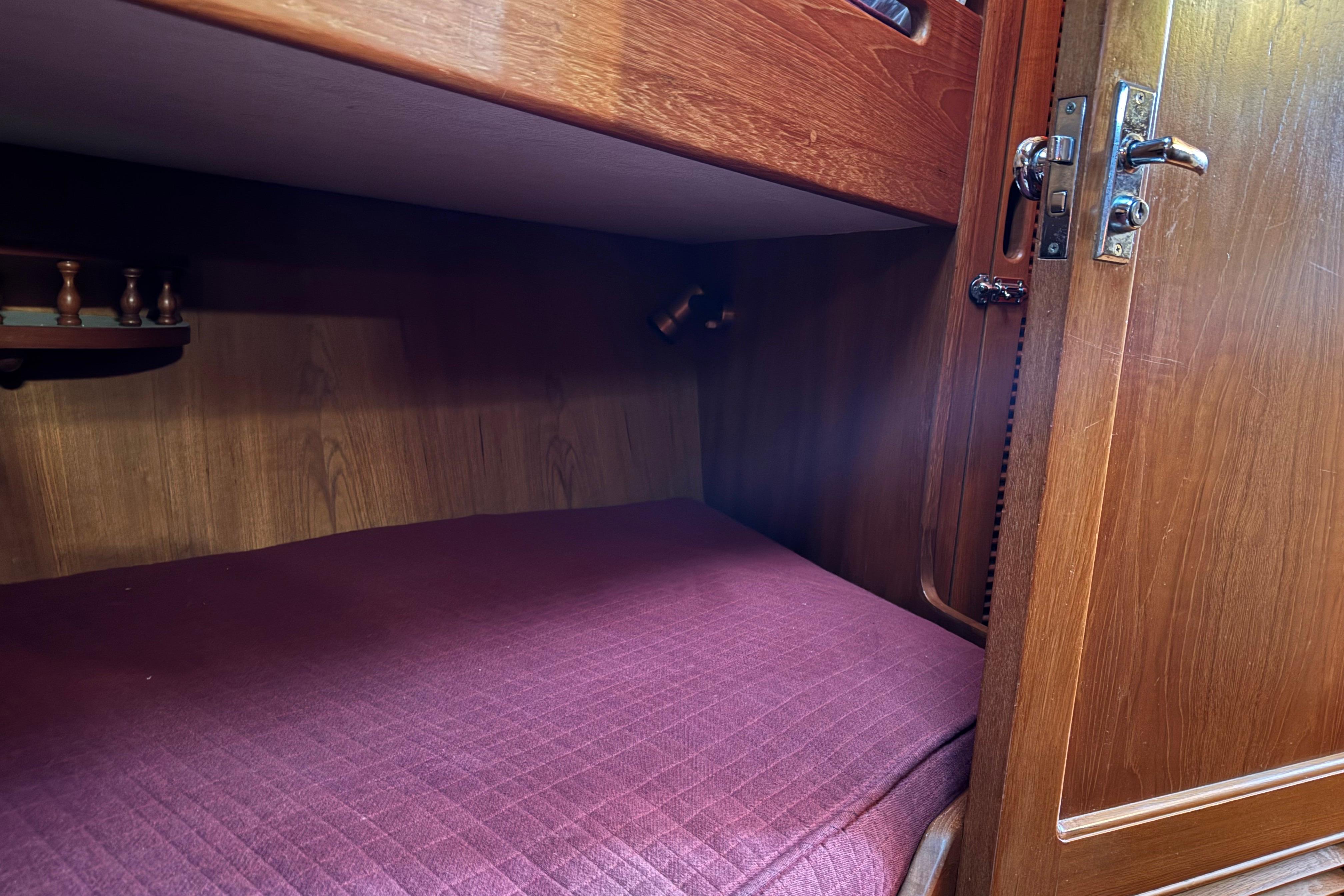 Cozy wooden cabin interior with a purple mattress, featuring vintage design elements.