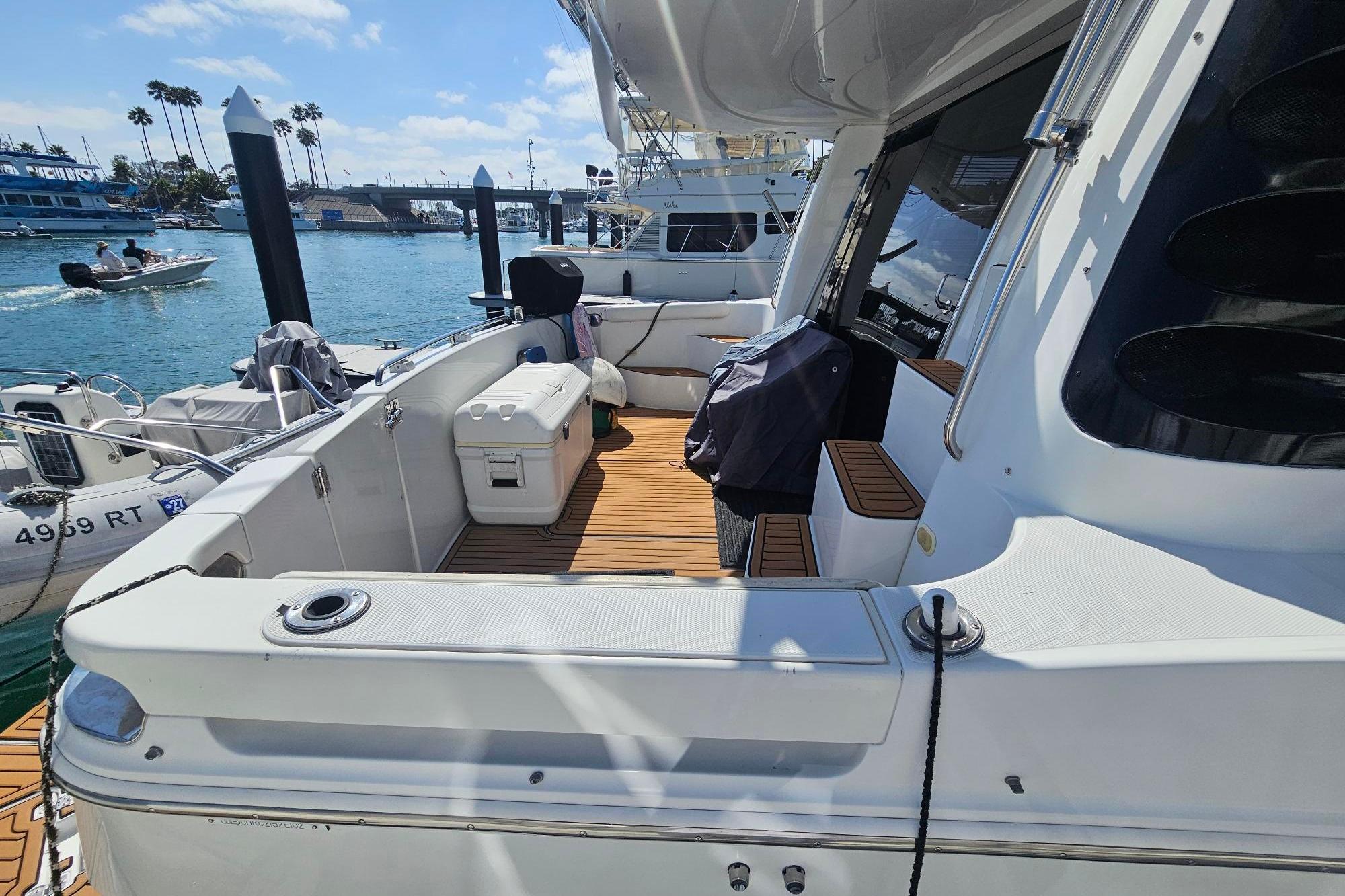 2002 Carver 450 Voyager Pilothouse yacht docked, featuring spacious deck and seating area.