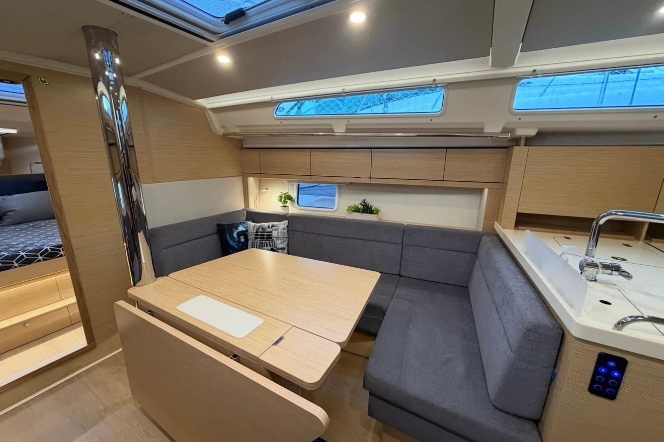 Modern interior of 2022 Hanse 418 yacht with cozy seating and dining area.