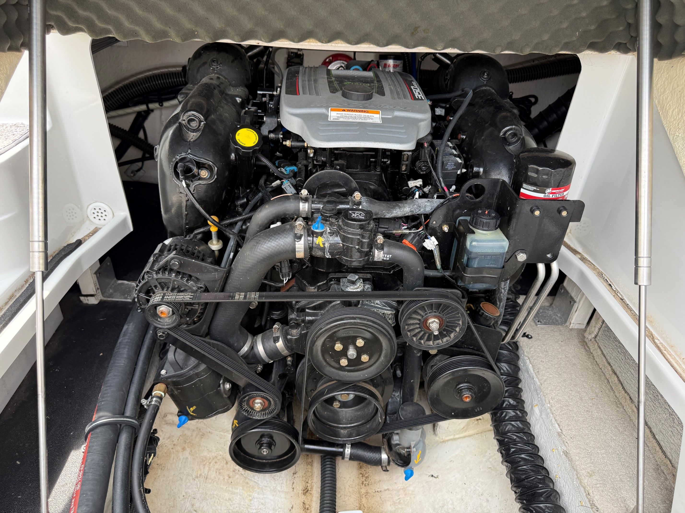 The engine compartment of a 2012 Crownline 252 EX boat shows a well-maintained engine.