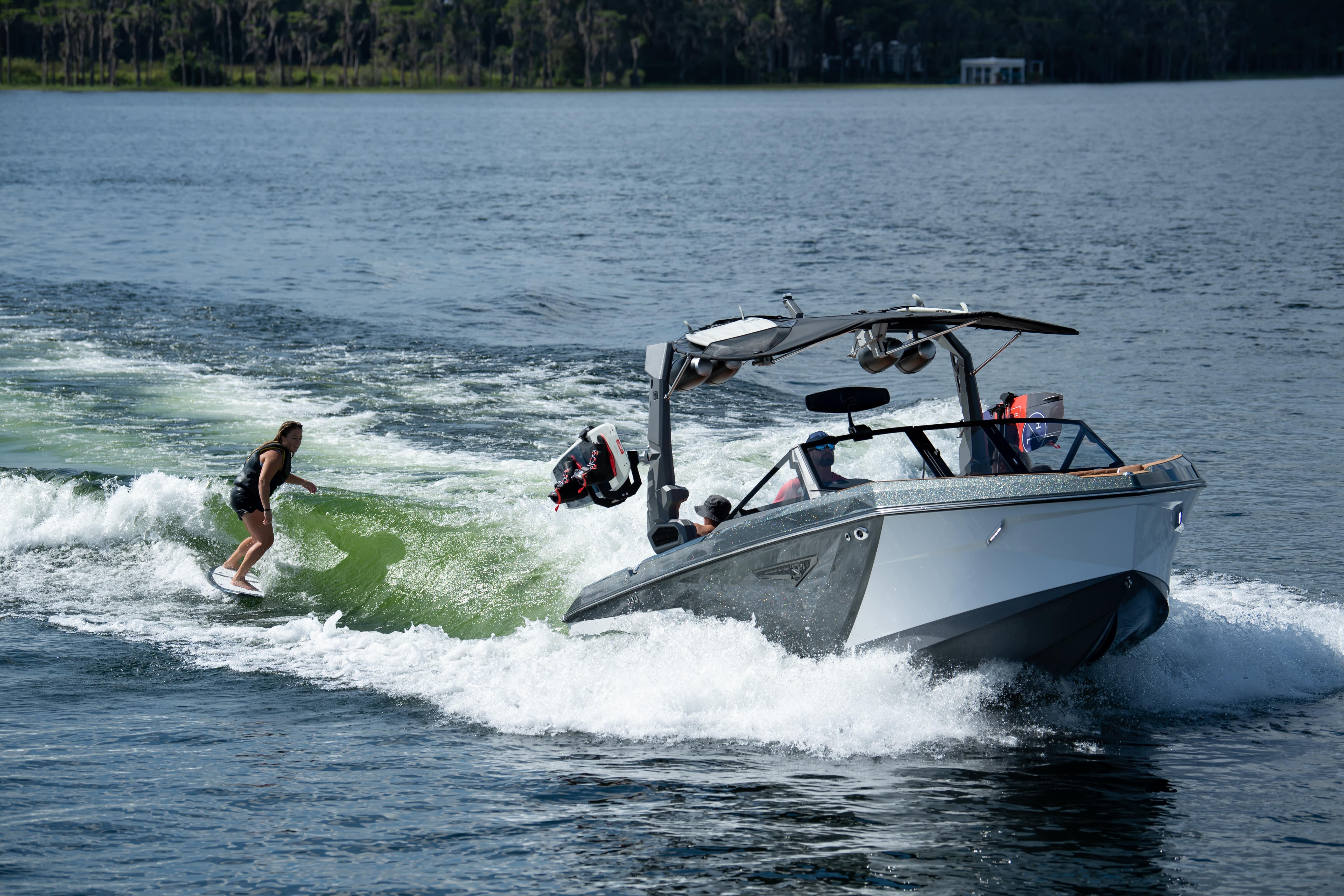 Nautique S21 MY2026 boat creating waves for wakeboarding on a lake.