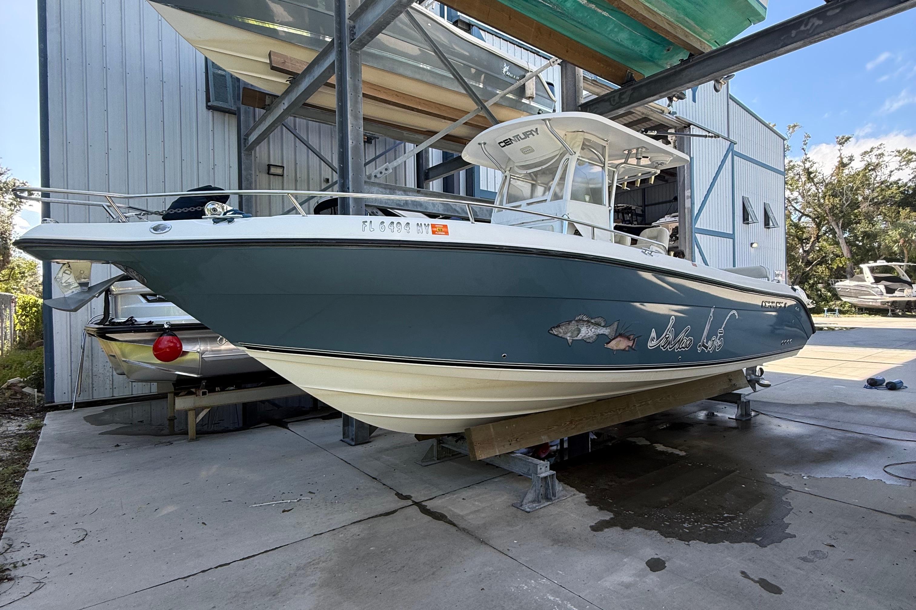 2008 Century 2901 Center Console boat on a lift, docked at a marina.