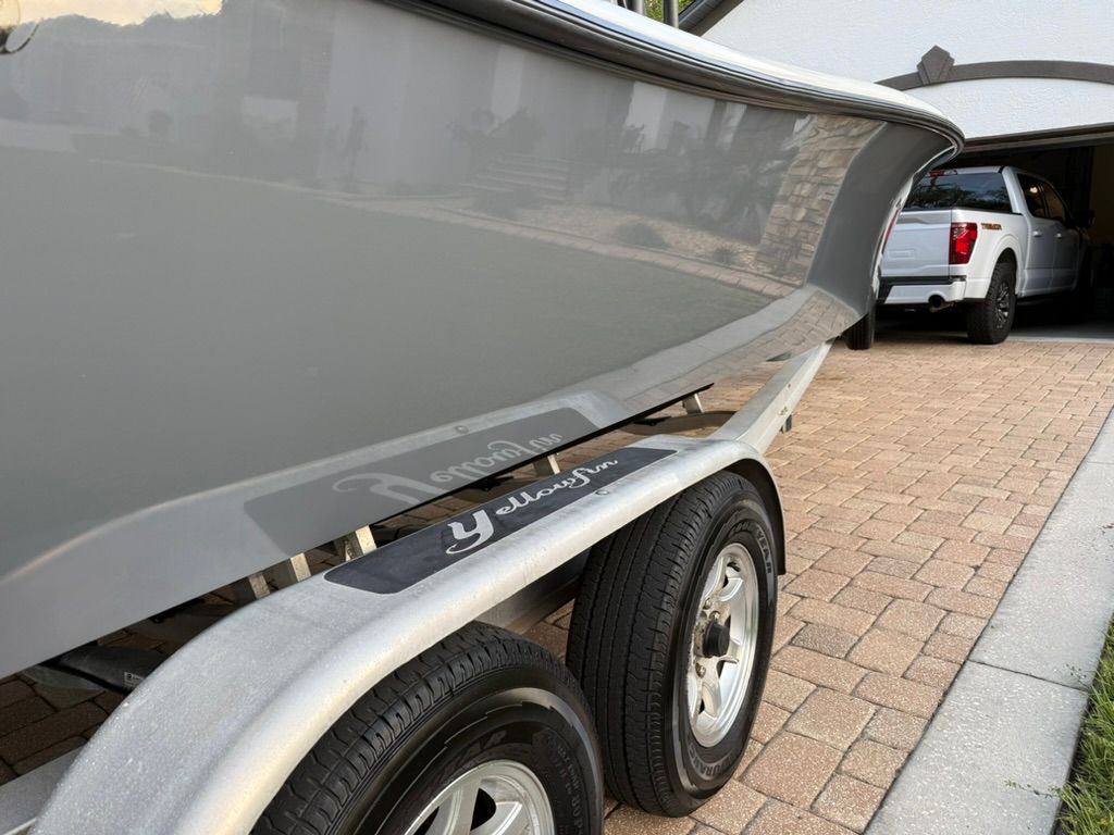 A 2020 Yellowfin 26 Hybrid on a trailer in front of a garage.