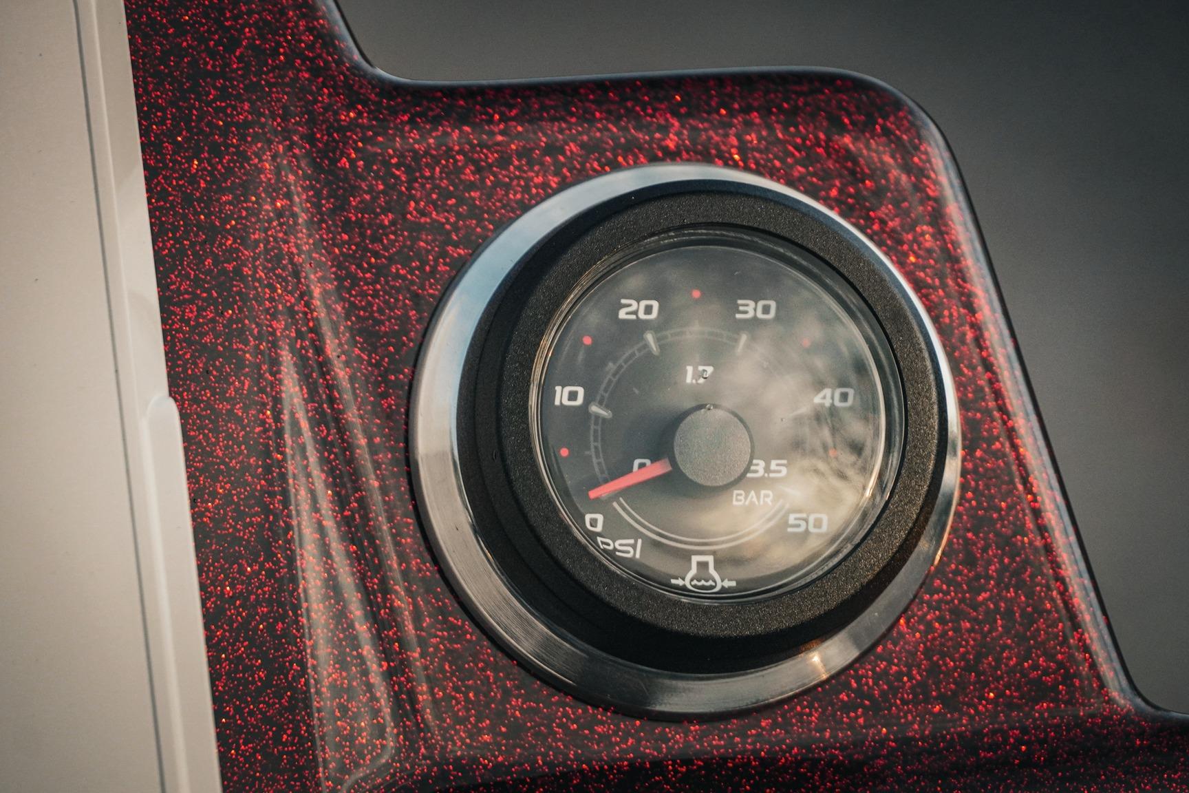 Close-up of 2026 Bass Cat Lynx STS gauge on a red-speckled dashboard.