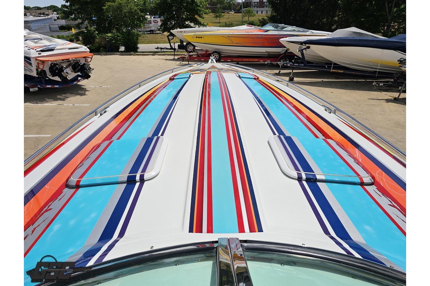 Colorful 2002 Formula 382 FASTech boat with vibrant stripes, parked among other boats.