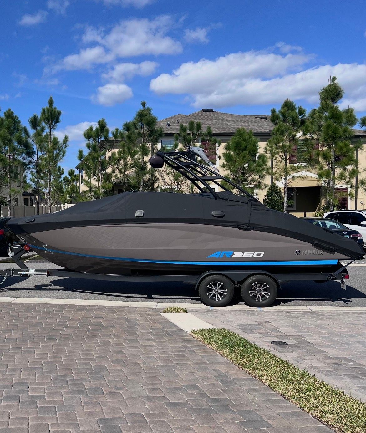 A 2022 Yamaha AR250 boat on a trailer in a residential area.