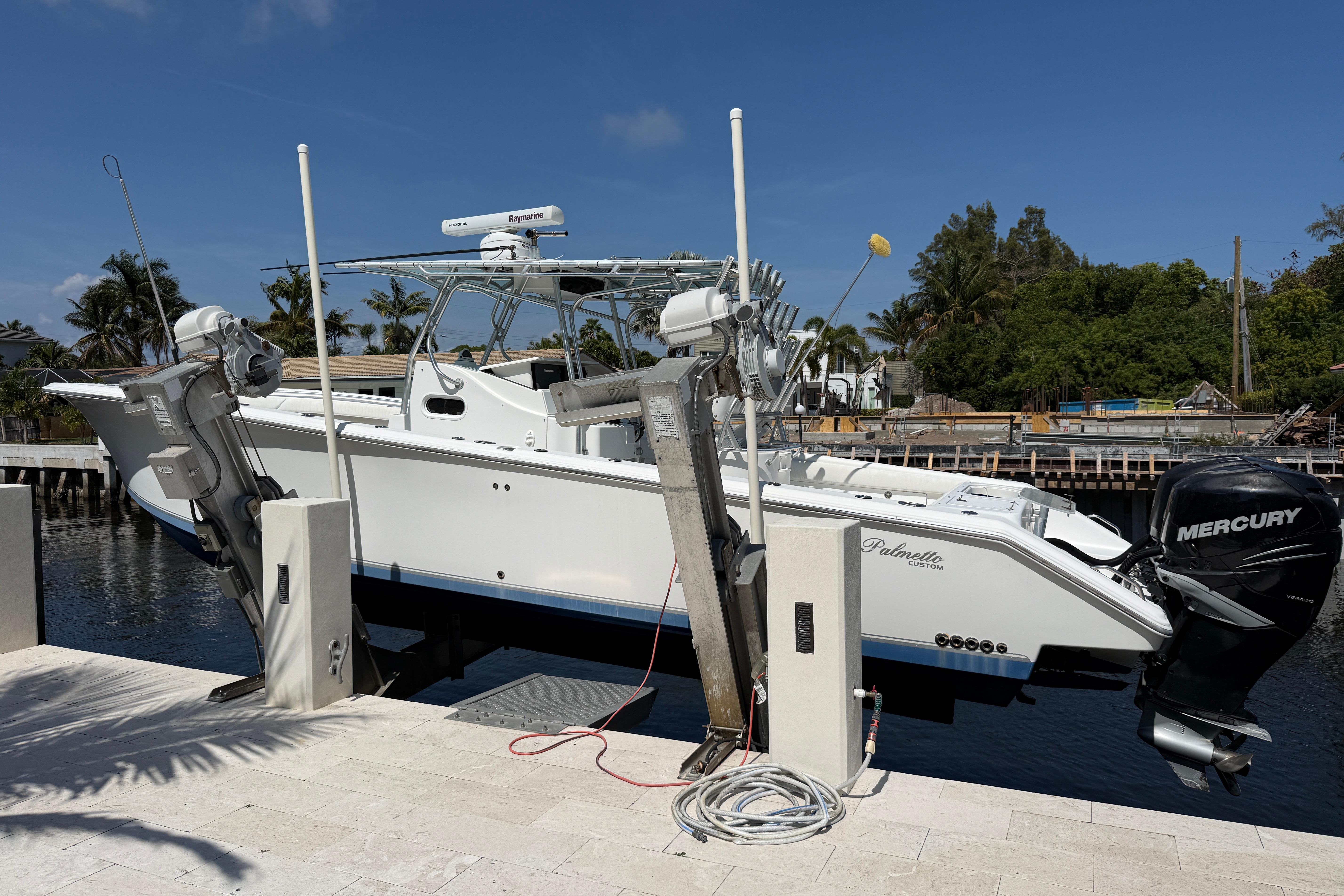 2003 Palmetto 33 Adventure boat on lift, featuring Mercury engines, docked by waterfront.