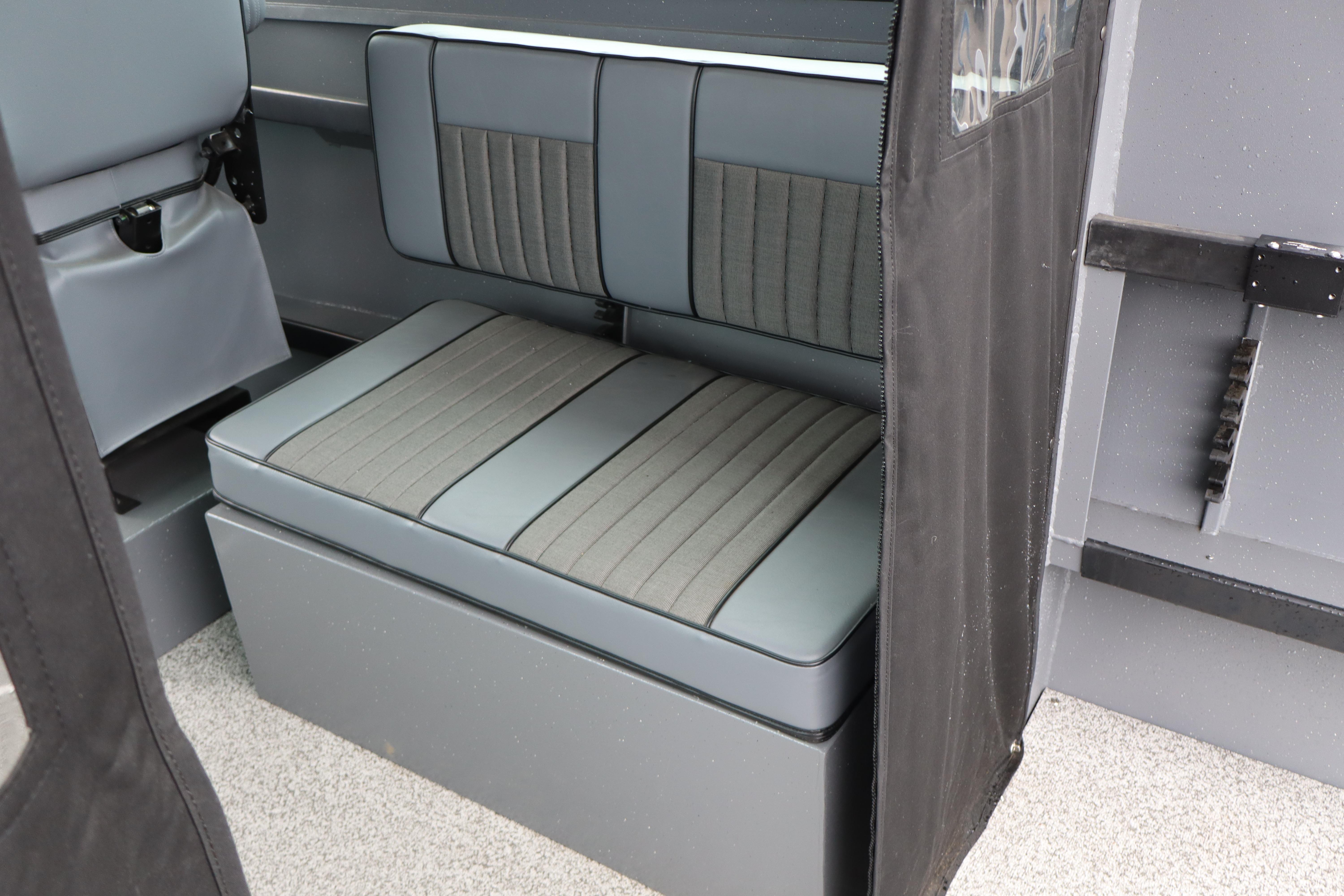2026 Alumaweld Horizon 24 interior seating with gray upholstery and storage compartment.