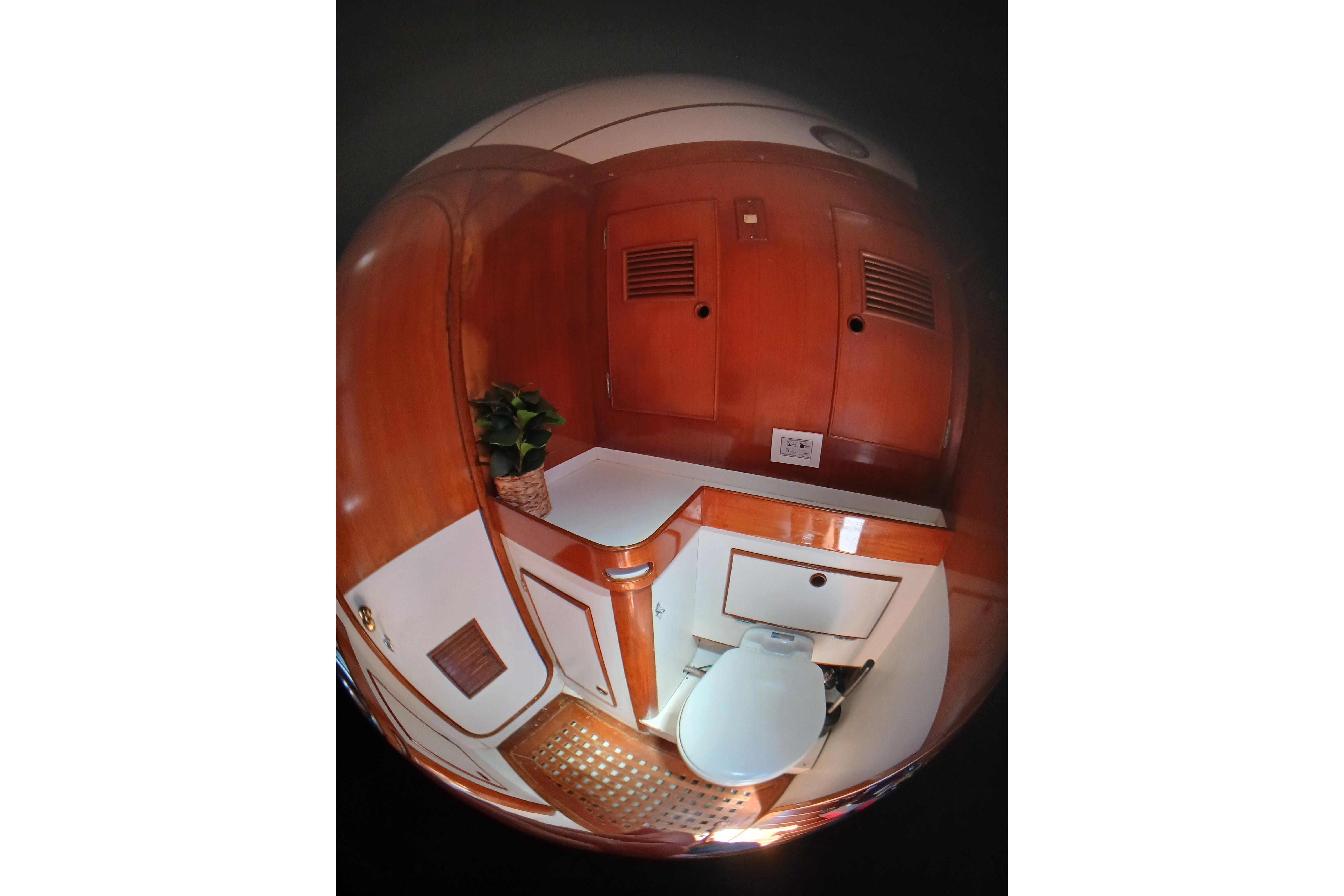 1981 SKYE 51 yacht bathroom with wooden cabinetry and white fixtures.