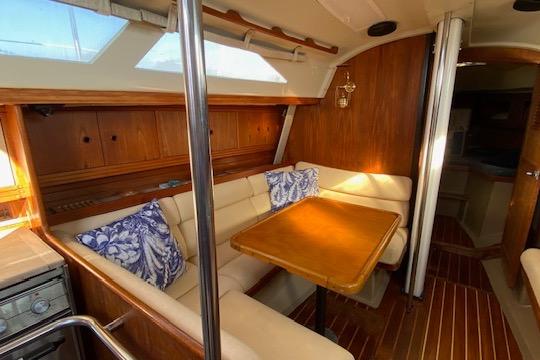 Interior of 1987 C&C Mark III sailboat with cozy dining area and wooden accents.