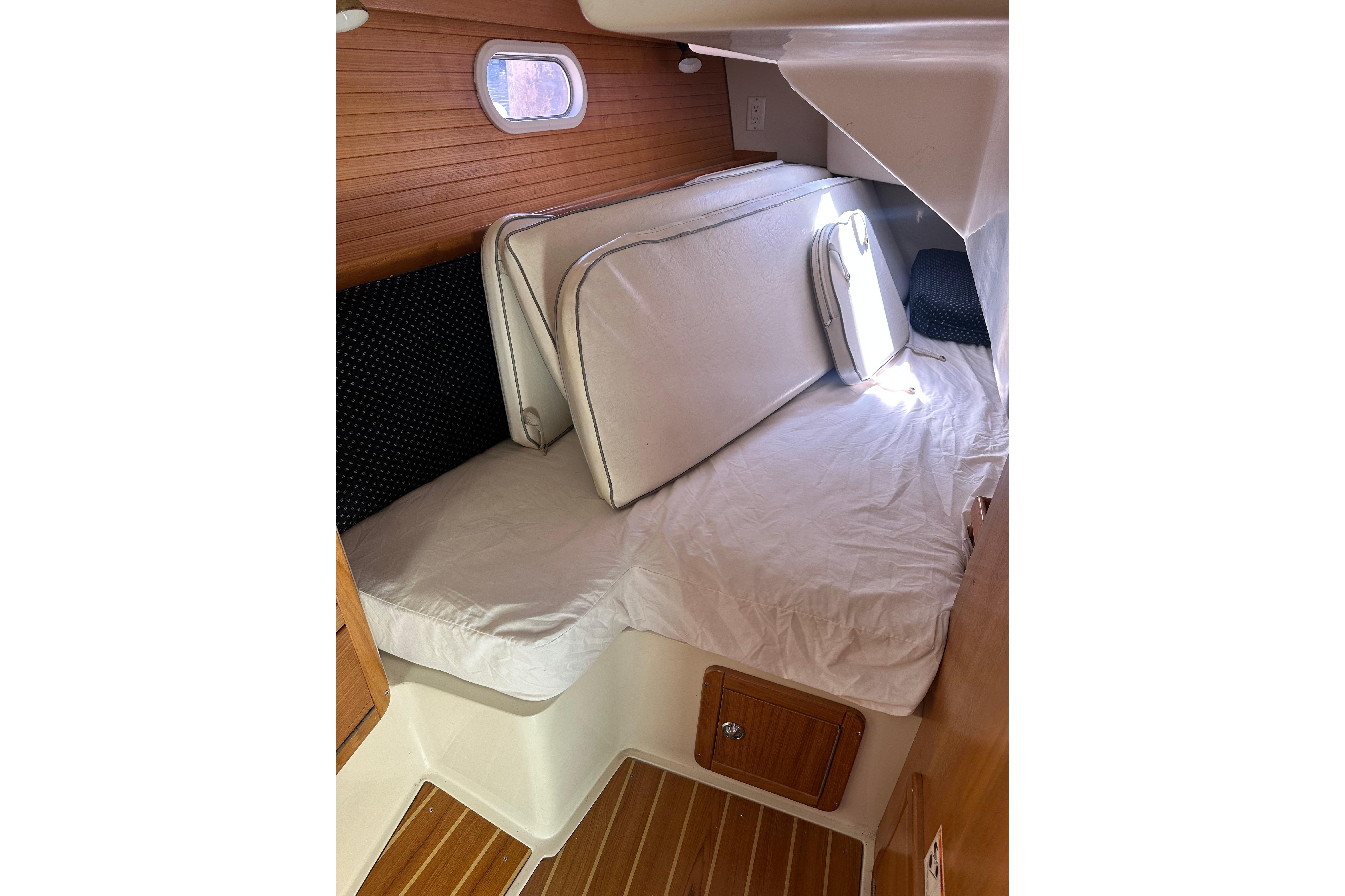 Interior cabin of 2005 Catalina 36 MkII sailboat with cushions and wooden accents.