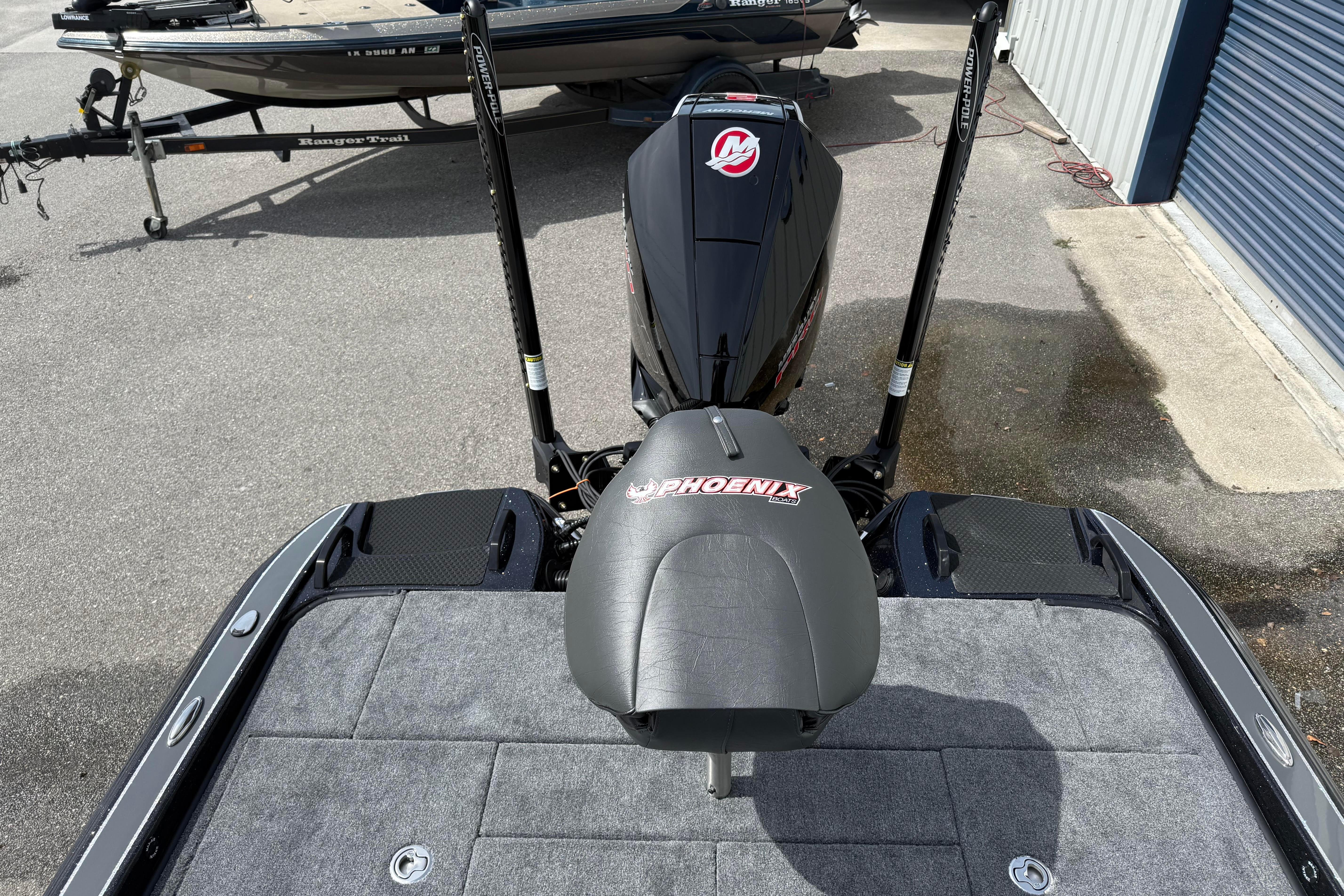 2027 Phoenix 921 Elite X boat with powerful engine and sleek design in a parking area.