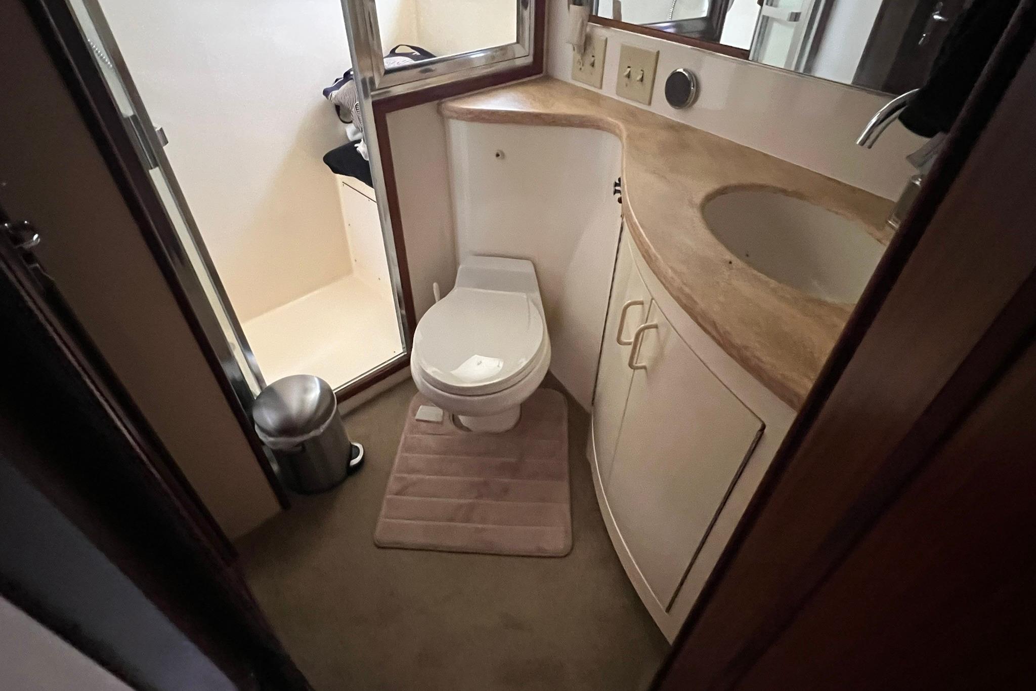 Bathroom interior of 1990 Hatteras 41 Convertible yacht, featuring toilet and sink.