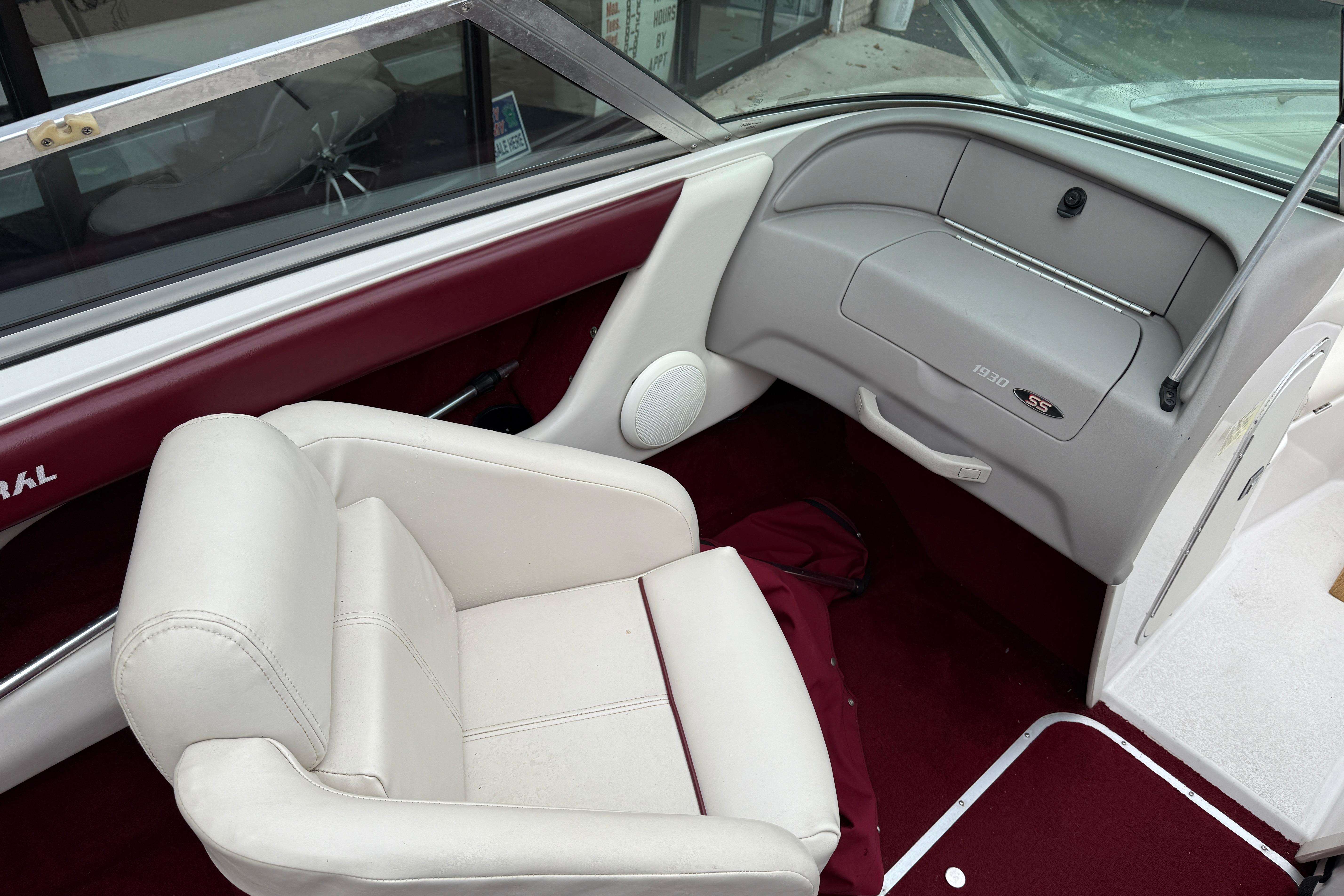Interior of a 1999 Chaparral 1930 SS boat with white seating and maroon accents.