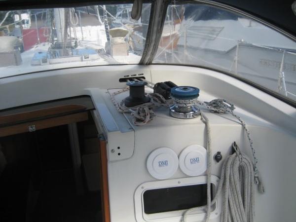 The cockpit of a sailboat with winches and ropes.