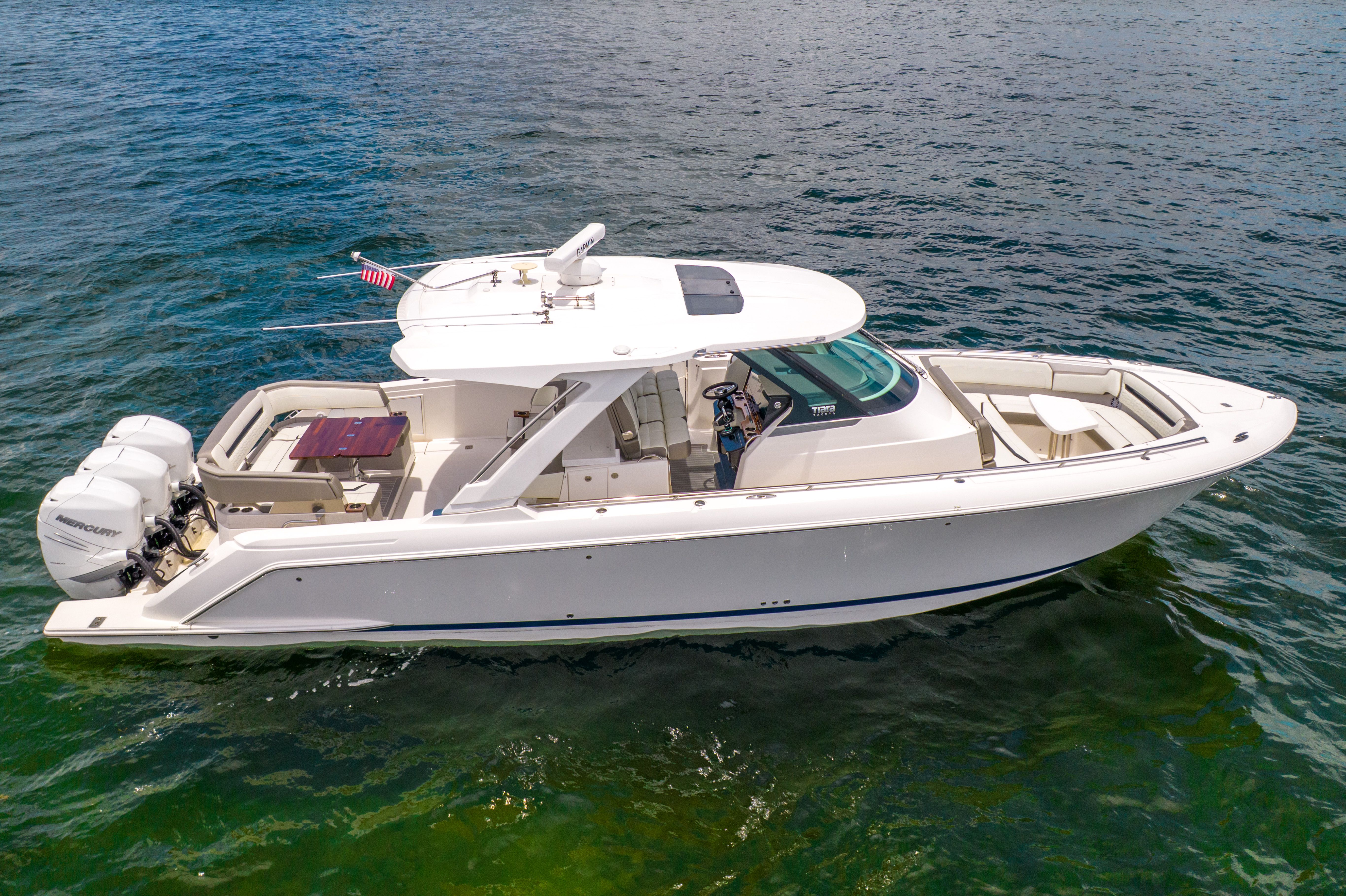 The 2023 Tiara Yachts 38 LS is a sleek boat on calm water, featuring a luxurious design.