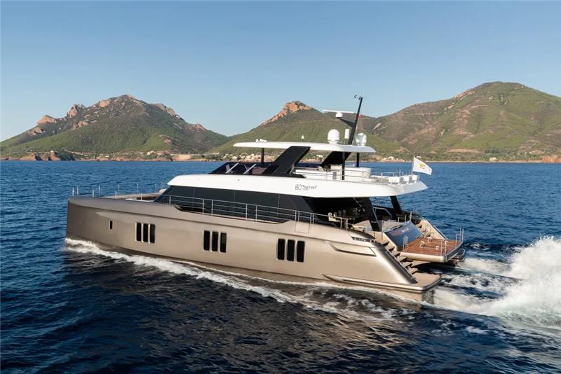 2026 Sunreef 80 Sunreef Power yacht cruising on open water with scenic mountain backdrop.