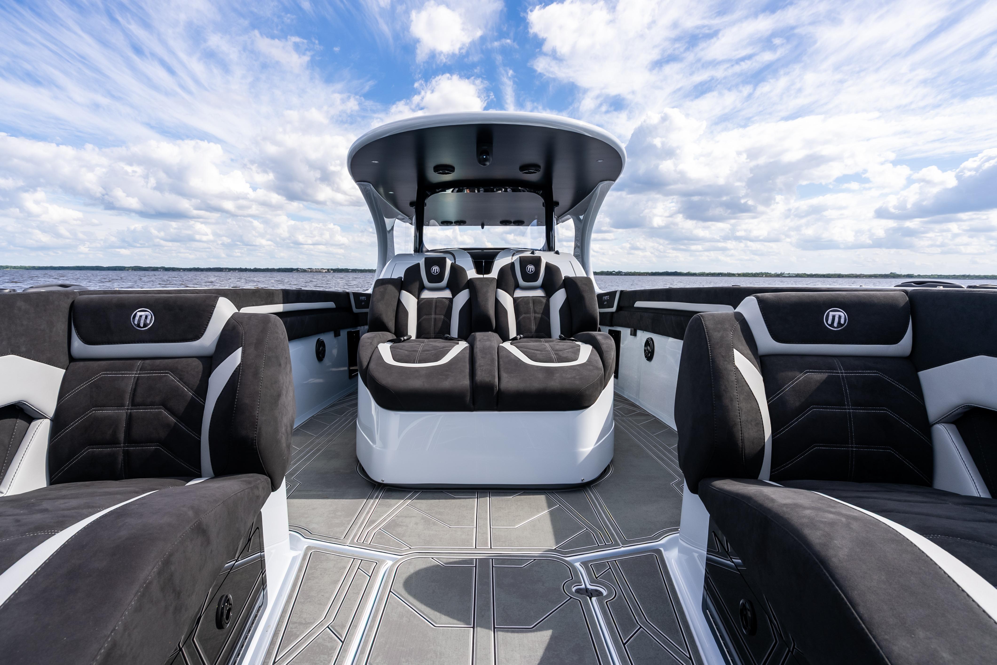 2027 Mystic Powerboats M4200 interior with luxurious seating and sleek design under a blue sky.