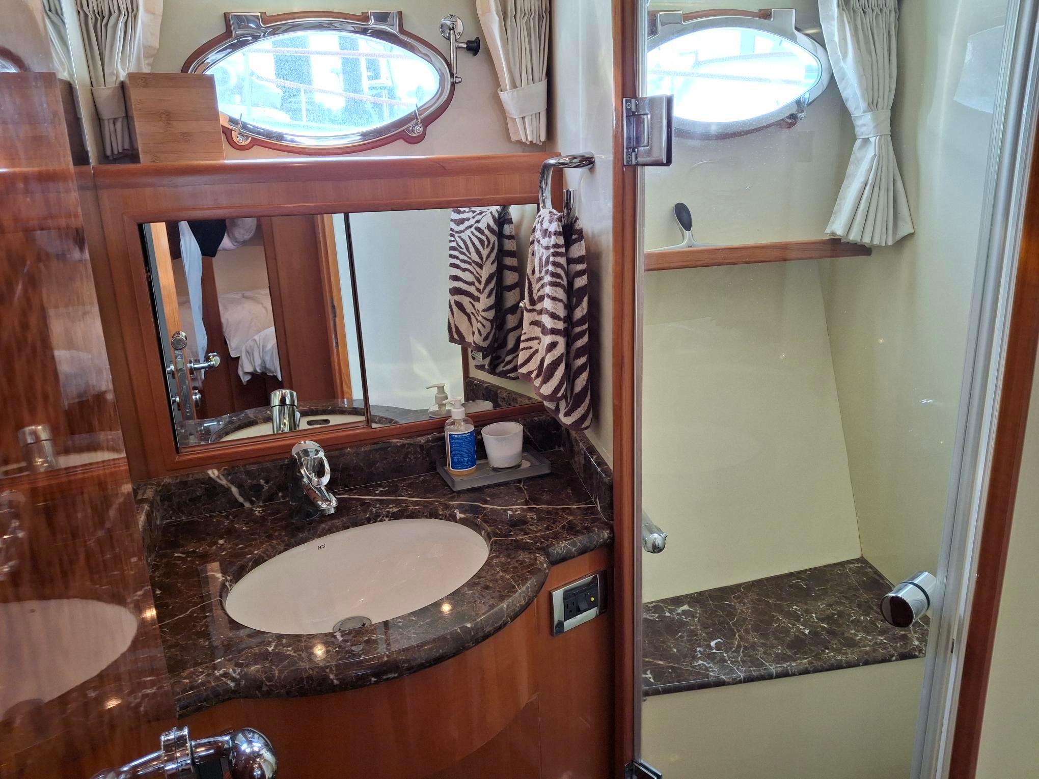 Luxurious bathroom in 2004 Ocean Alexander 64 Pilothouse yacht with marble countertop and shower.