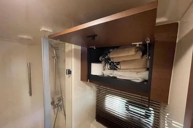 Bathroom storage in 2016 Sea Ray Sundancer 510 yacht with towels and shower area.