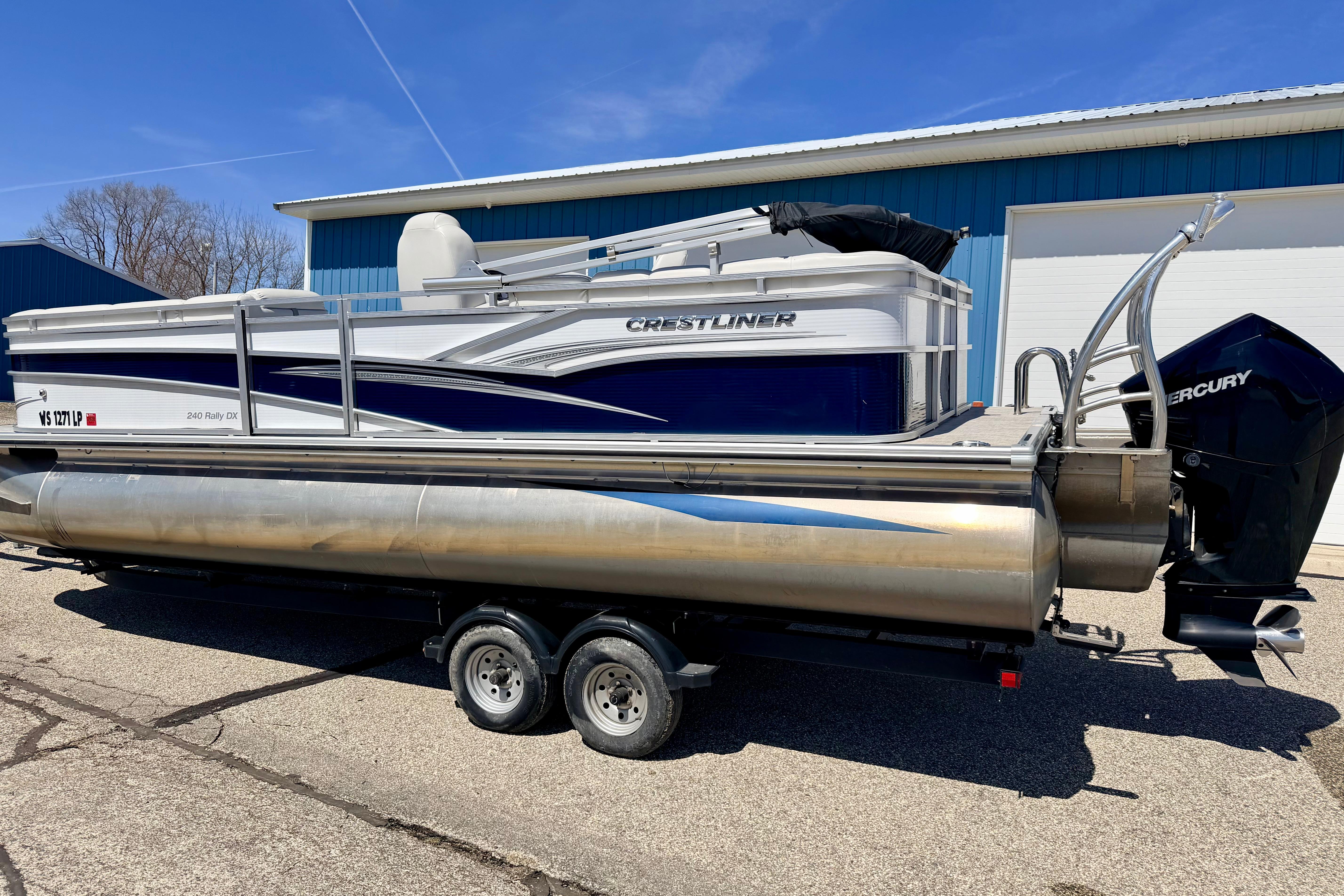2019 Crestliner 240 Rally DX CW pontoon boat on trailer, parked outdoors.