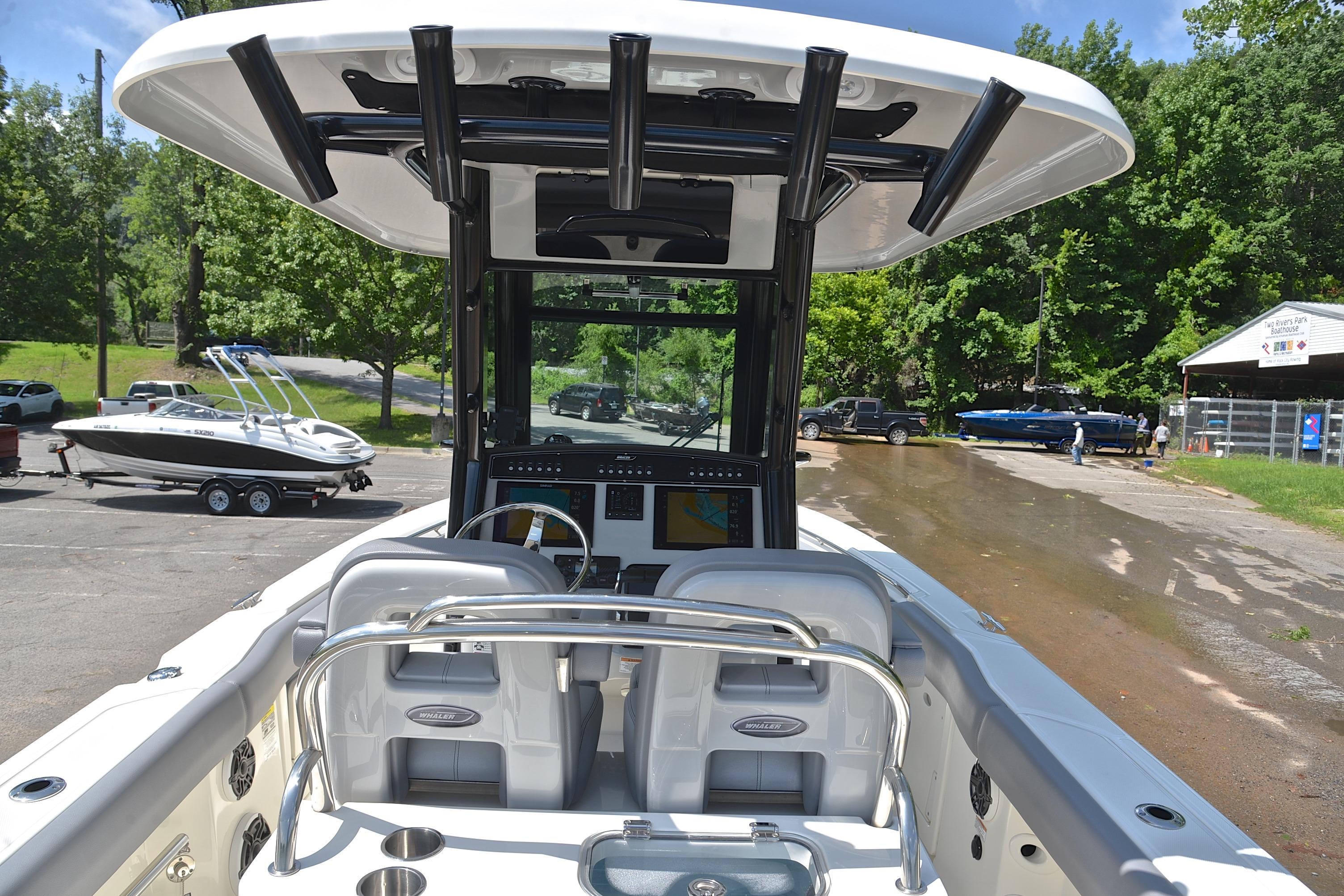 2024 Boston Whaler 250 Outrage boat interior with helm and seating, docked near a boat ramp.