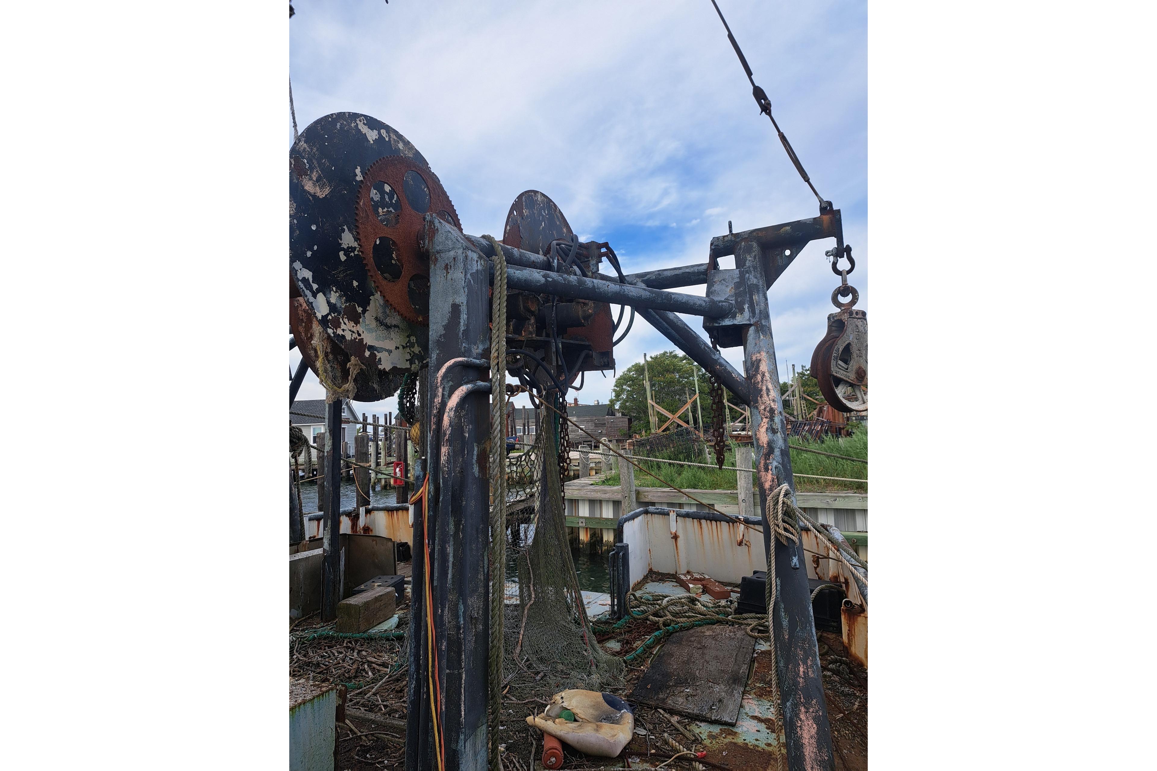 Rusty 1979 Custom Steel Trawler Dragger with fishing equipment and netting.