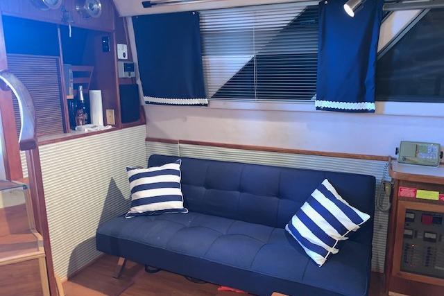 Interior of 1987 Sea Ray 410 Aft Cabin with blue sofa and striped pillows.