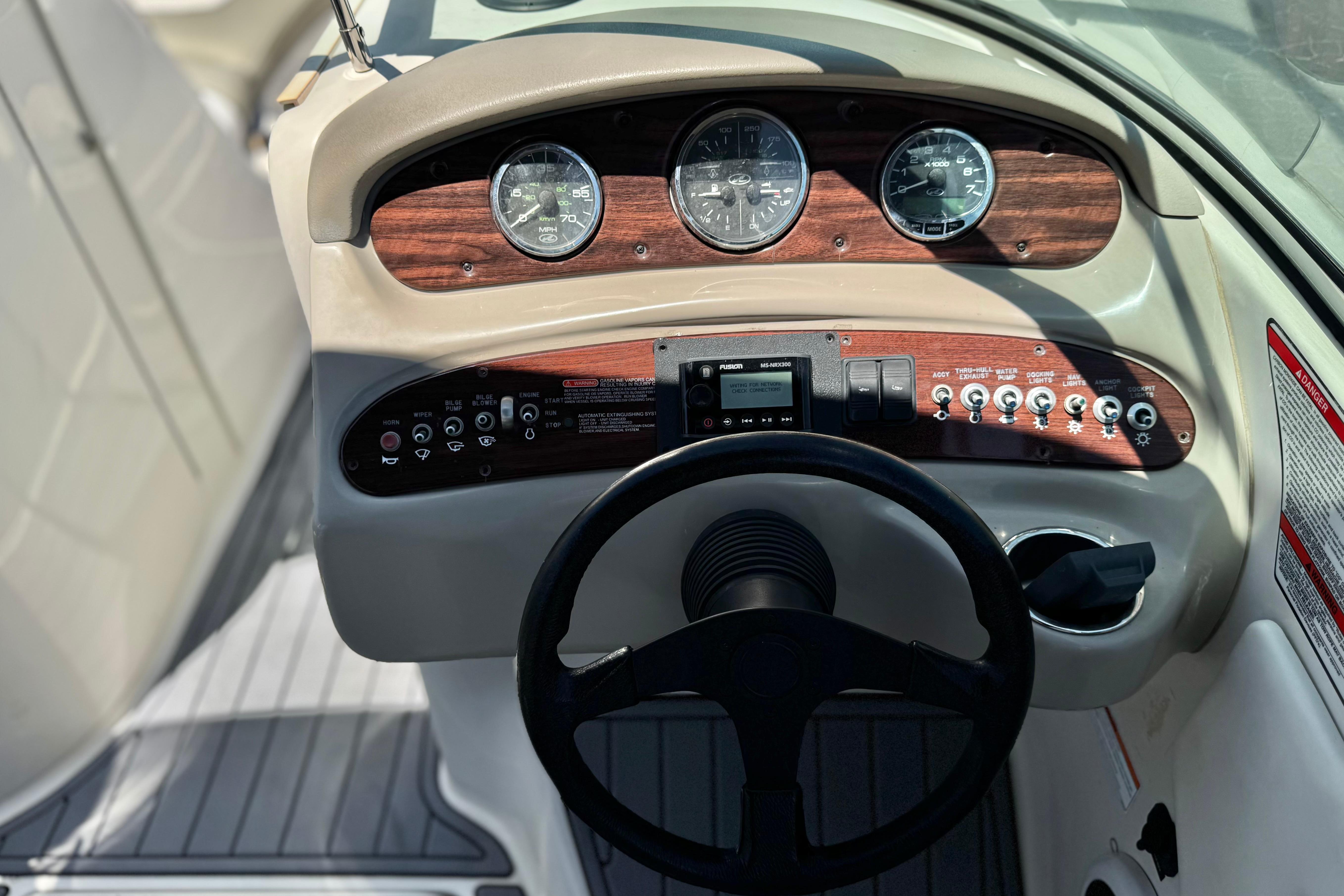 2007 Sea Ray 240 Sundeck dashboard with gauges, steering wheel, and control panel.