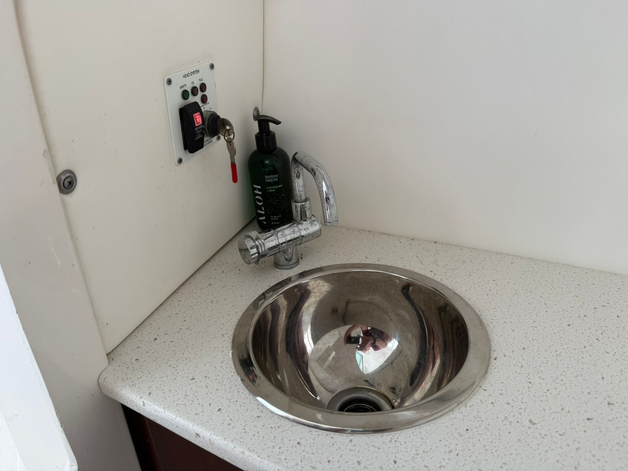A sink with a faucet and soap dispenser on a countertop.
