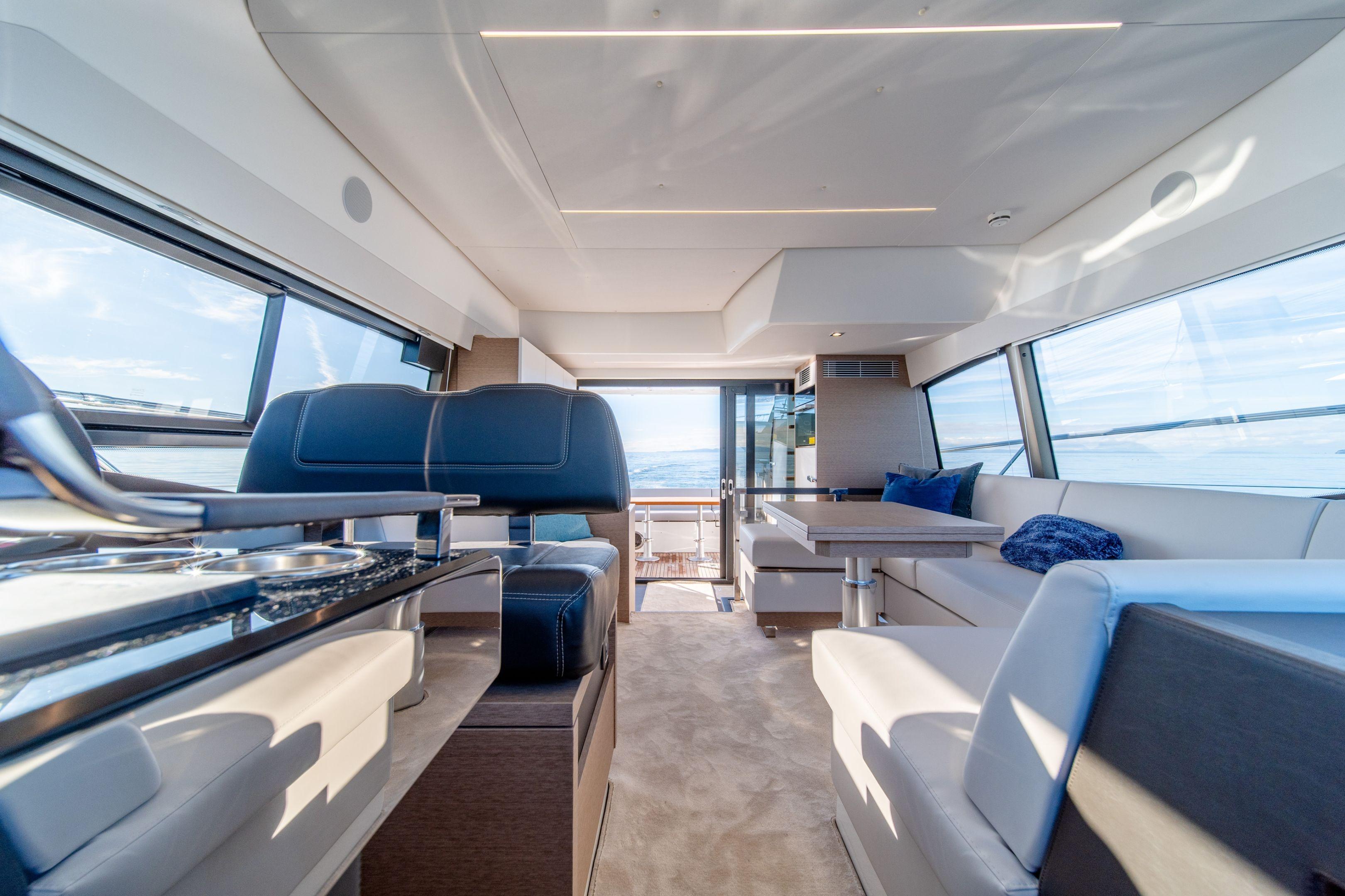Luxurious interior of 2026 Prestige 460 yacht with modern seating and panoramic windows.