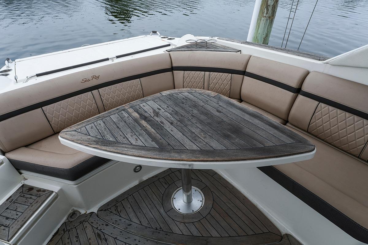 Luxurious seating area on a 2018 Sea Ray SLX 350 boat with wooden table.