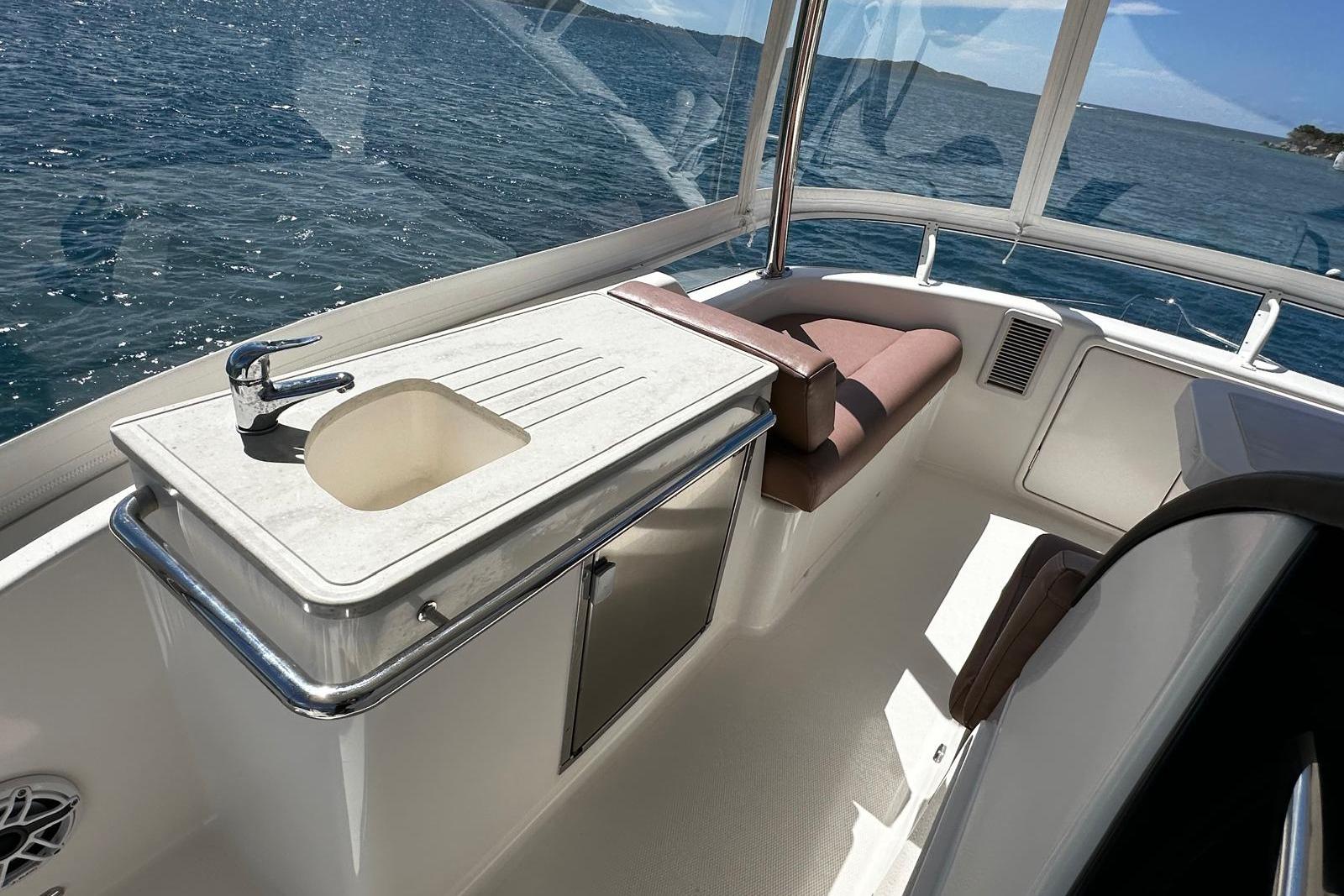Flybridge interior of 2012 Riviera 43, featuring a sink and seating with ocean view.