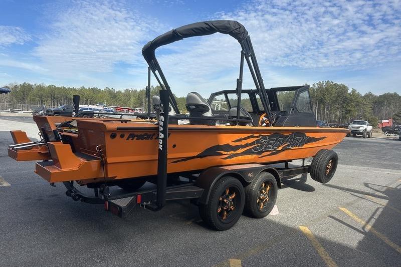 2026 SeaArk ProCat 240 boat on trailer, vibrant orange design, parked outdoors.