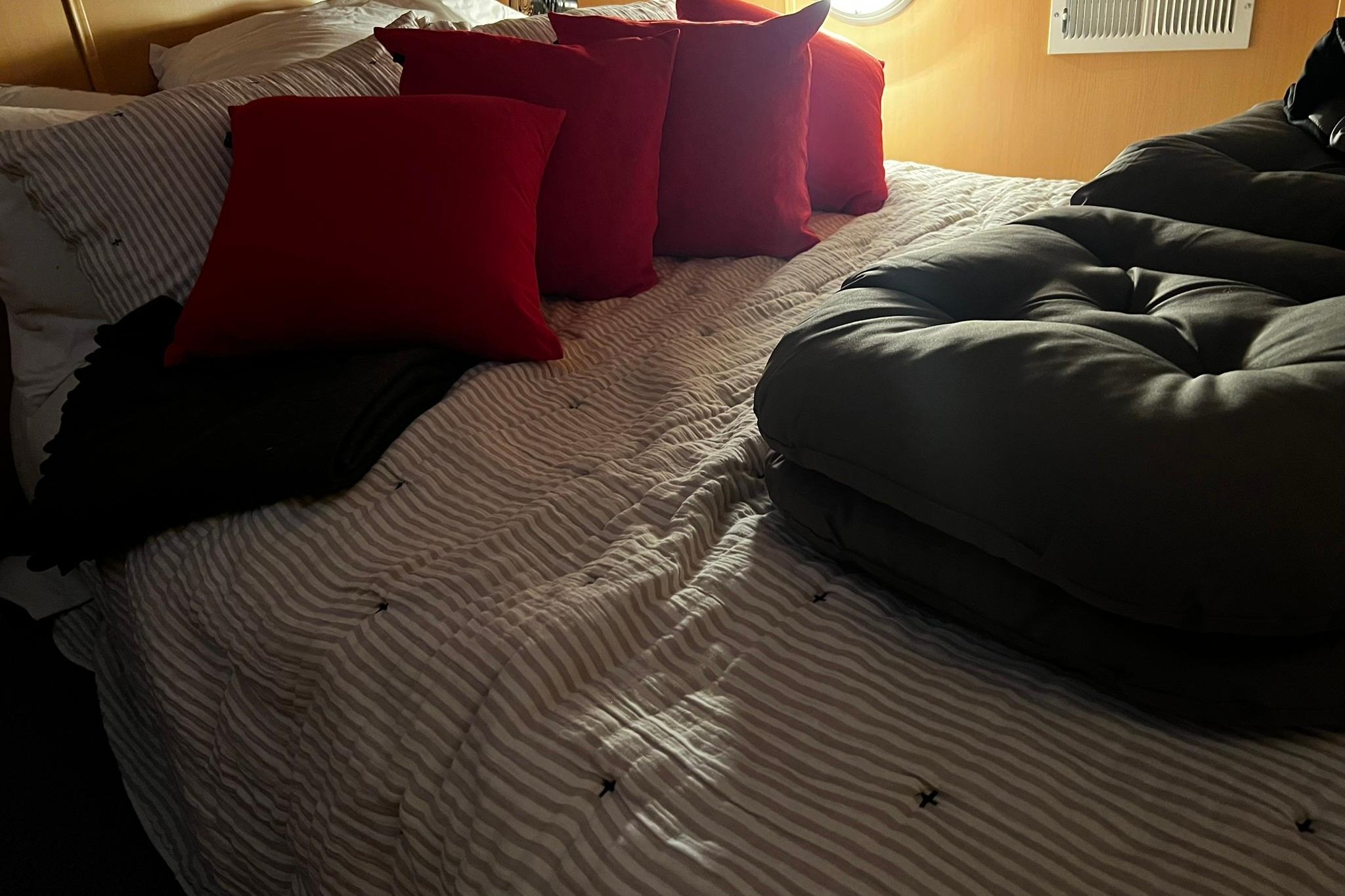 Cozy cabin bed with red pillows on Skipperliner 480 Flybridge, 2010 model.