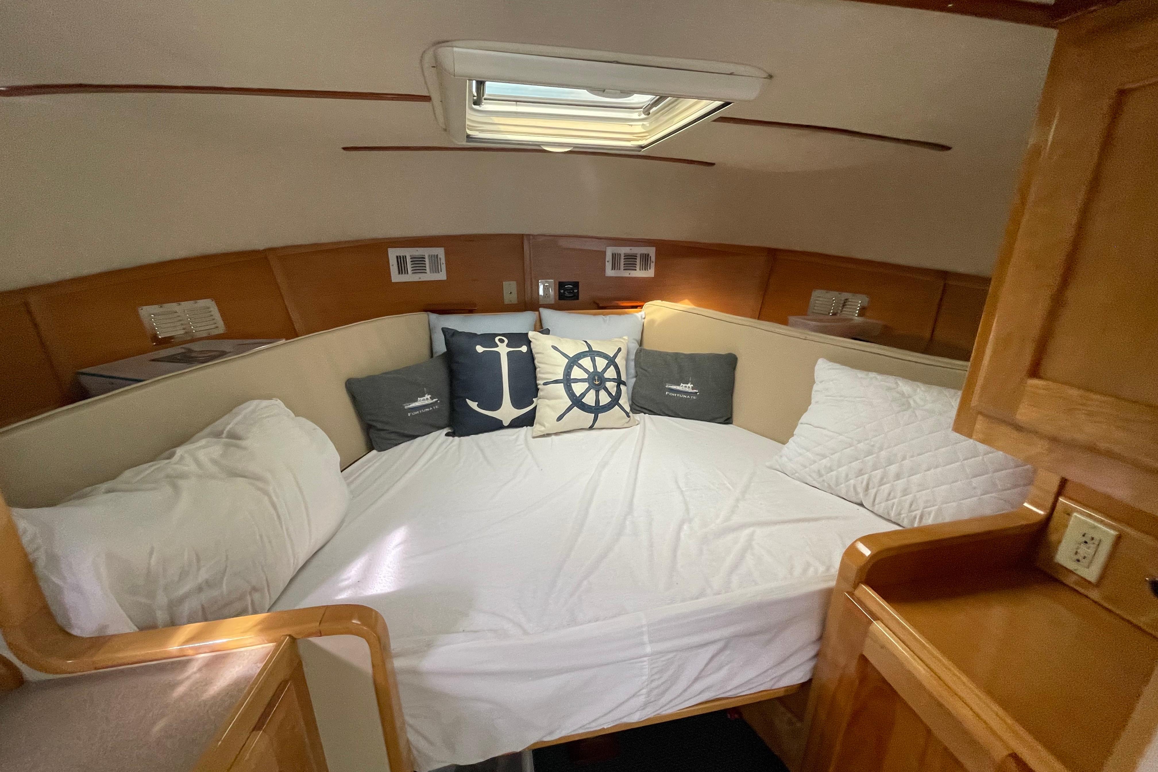Cozy cabin interior of 2005 Fox Island Thirty Sedan Cruiser with nautical-themed pillows.