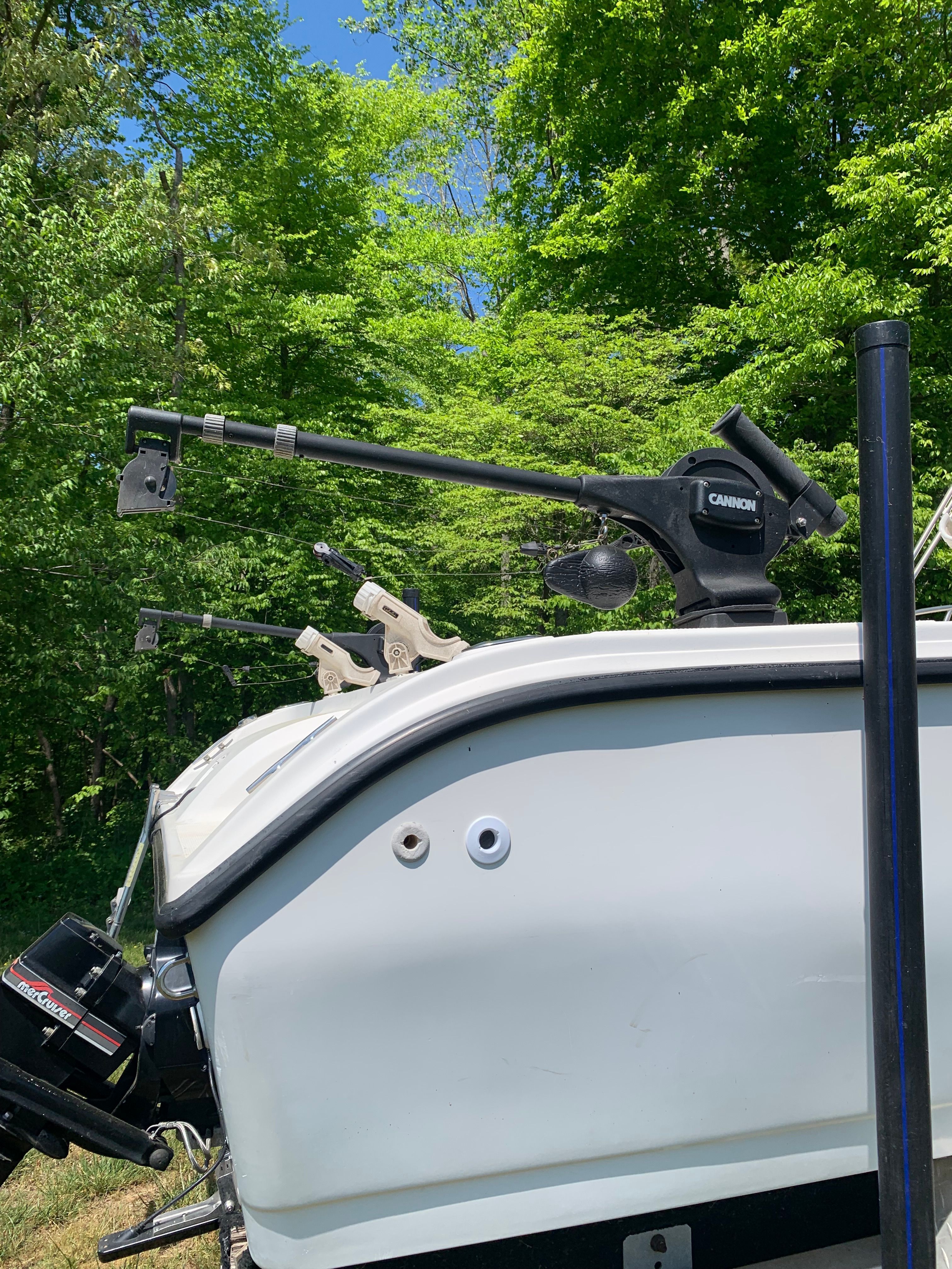 1998 Eurosport 221WA boat with fishing rod holders in forest setting.