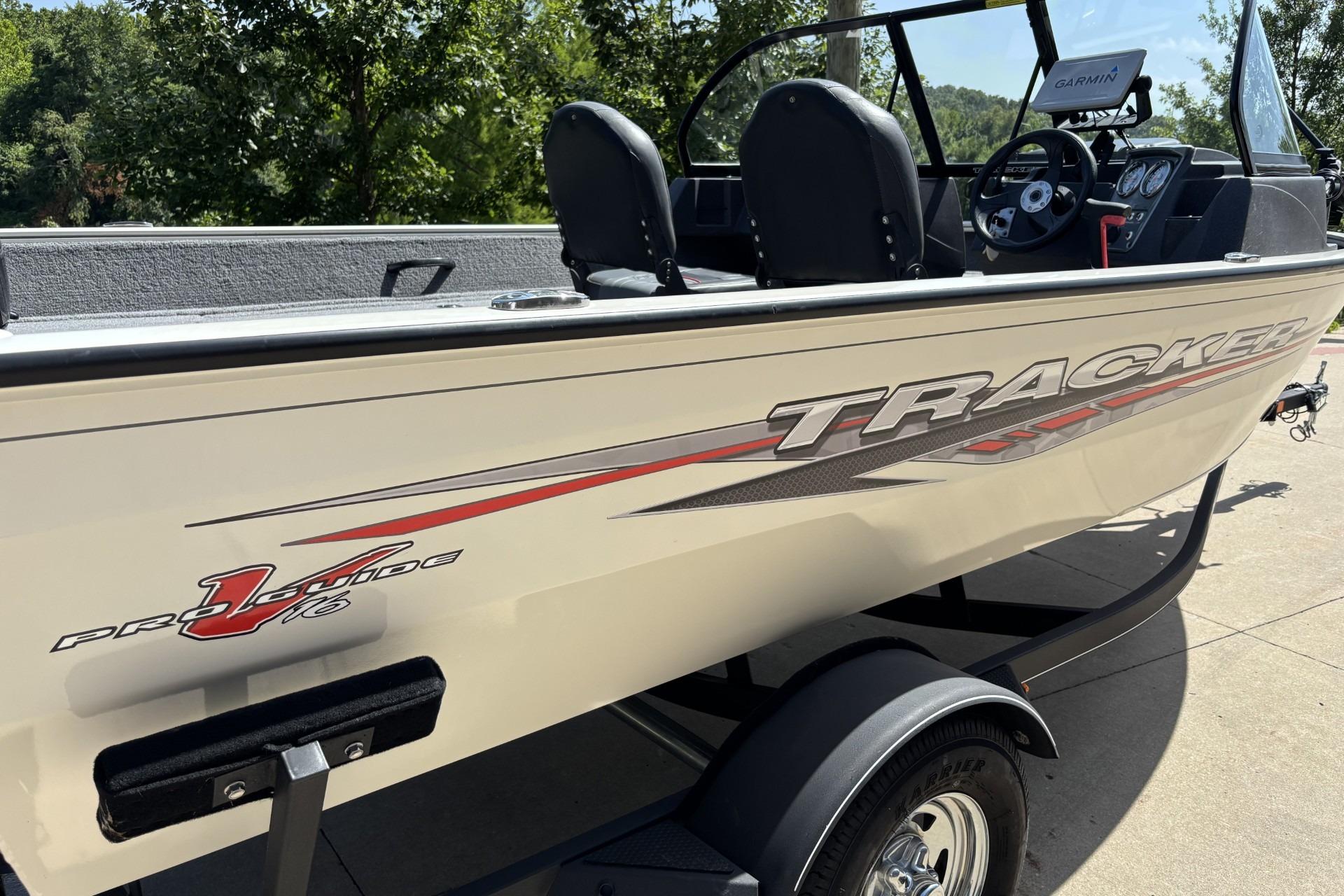 2022 Tracker Pro Guide V-16 SC boat on trailer, side view with logo and seats visible.
