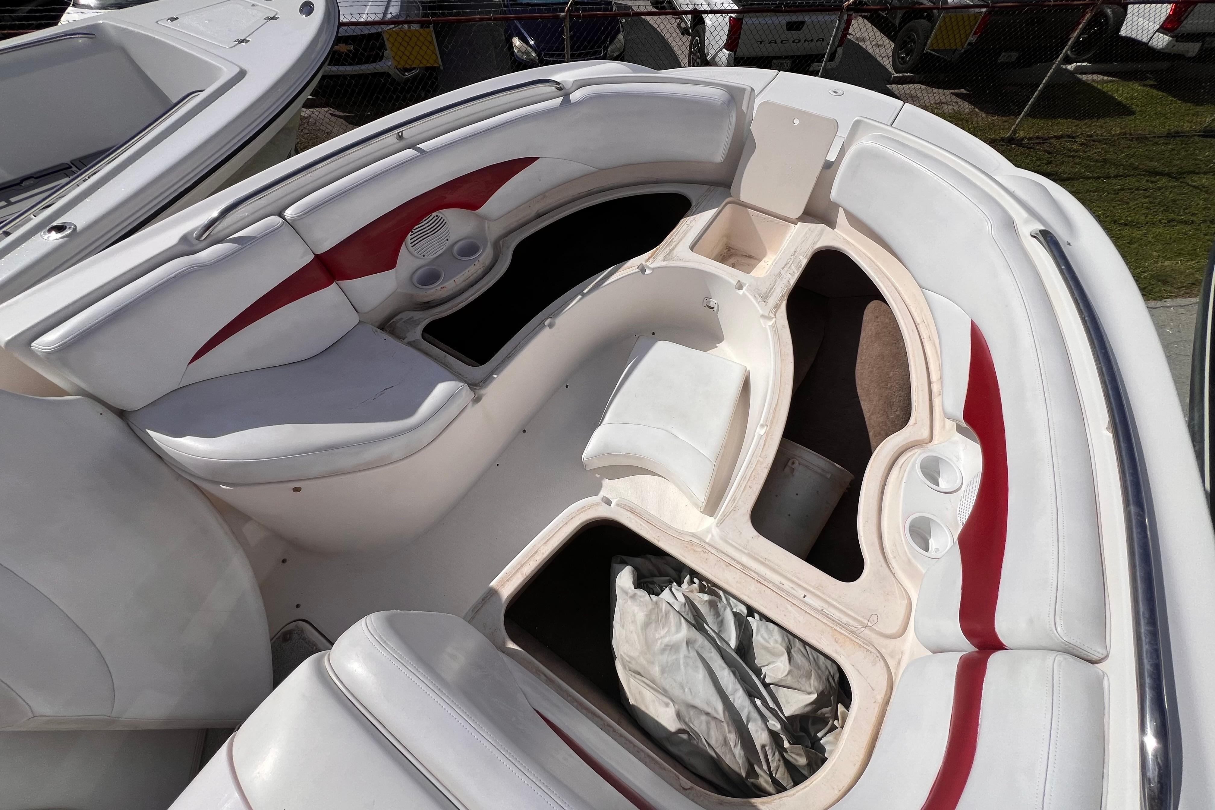2002 Chaparral 232 Sunesta boat interior with white and red seating, storage compartments.