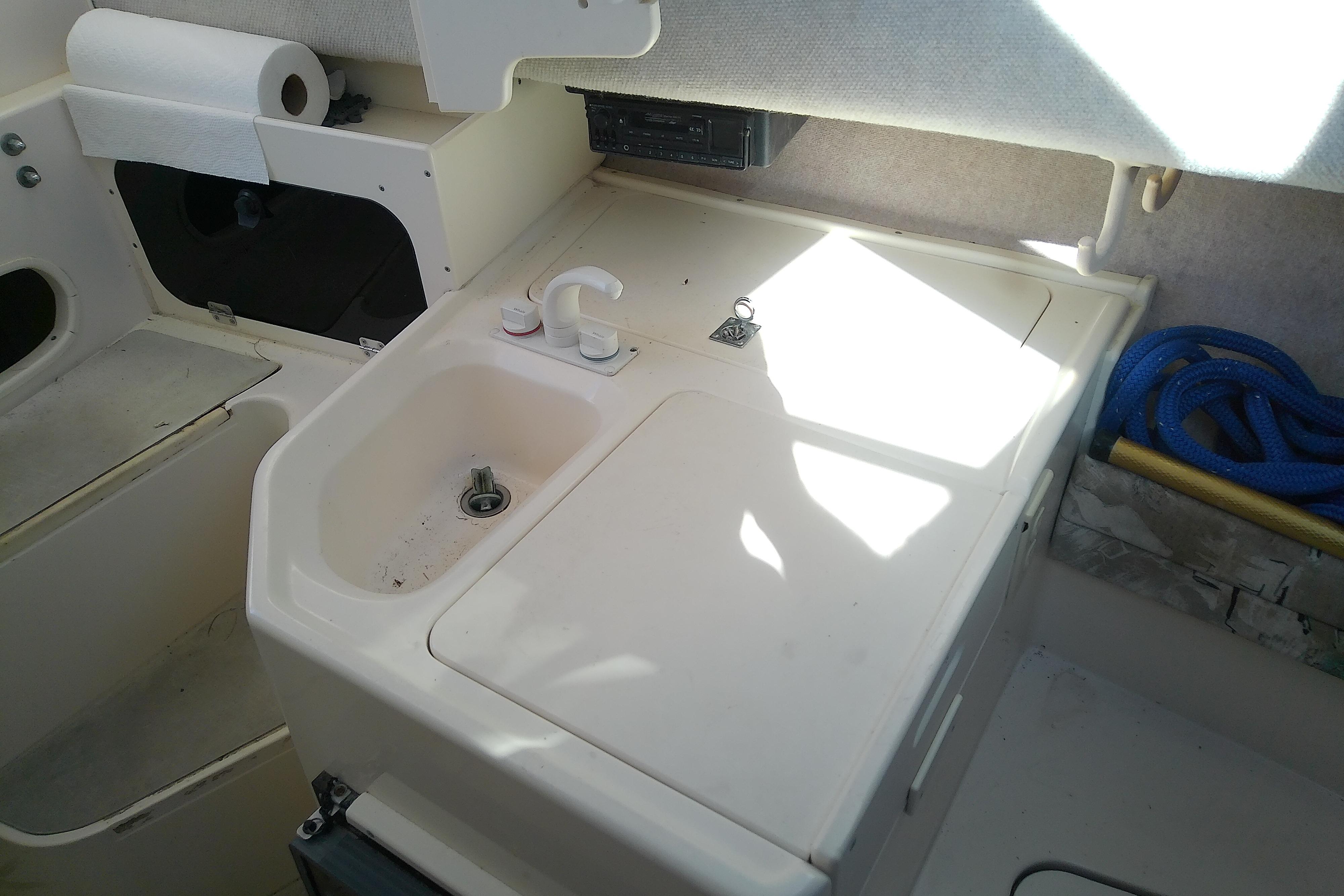 Interior of a 1995 Grady-White Sailfish 272 boat with sink and storage area.