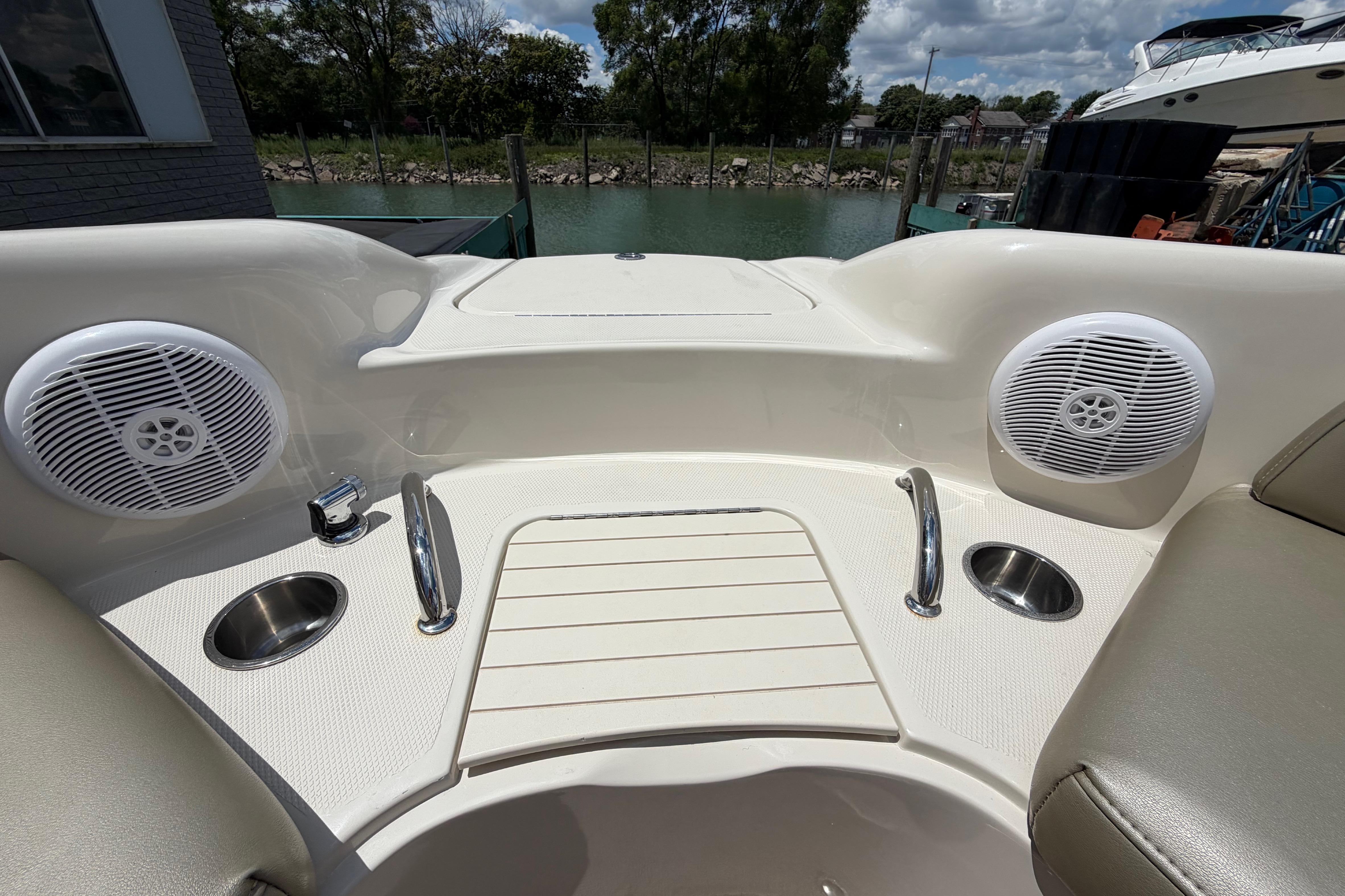 2004 Sea Ray 240 Sundeck boat interior with speakers and cup holders, docked by the water.