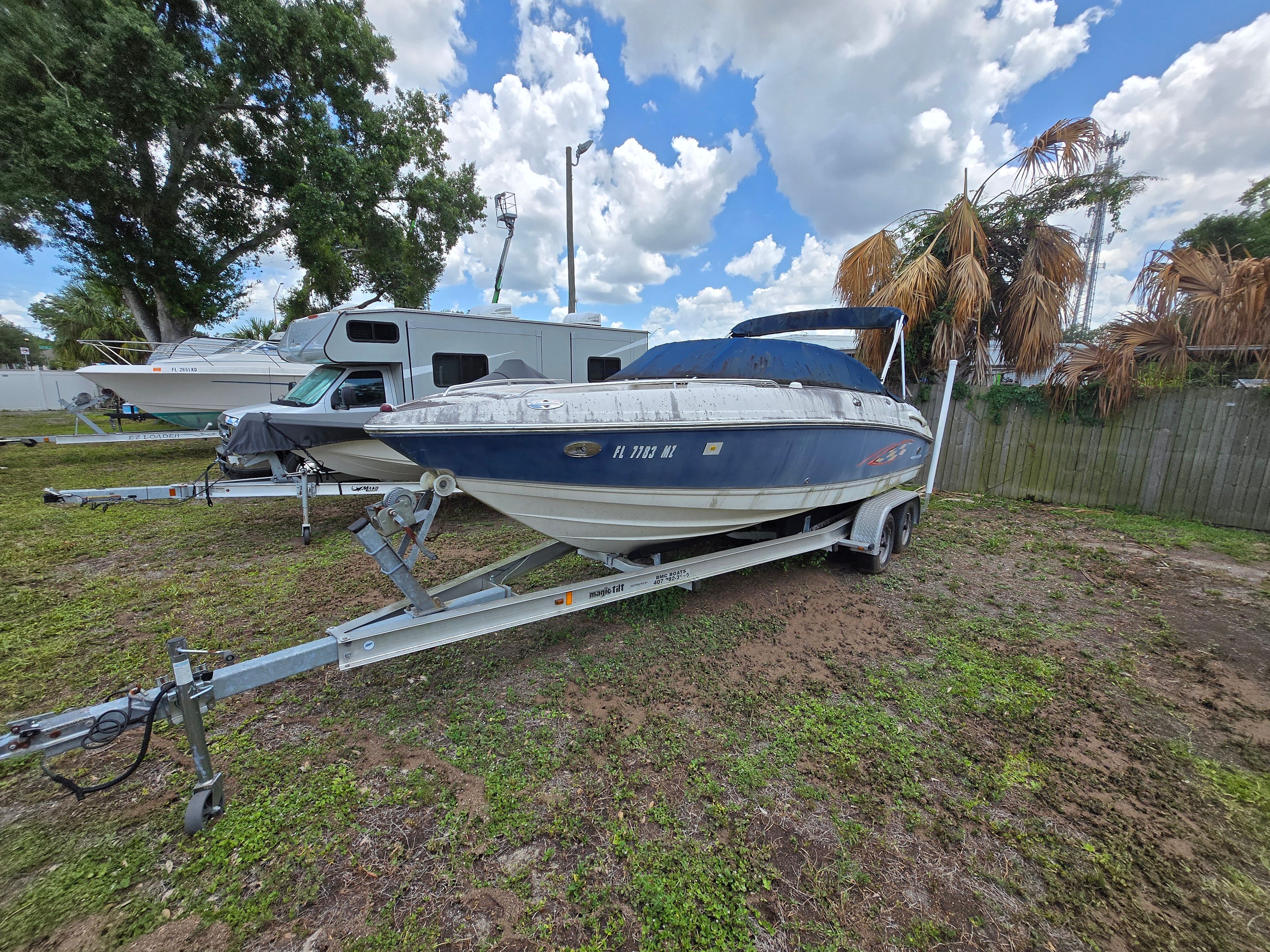 A 2006 Chaparral 220 SSi boat on a trailer in a grassy area.