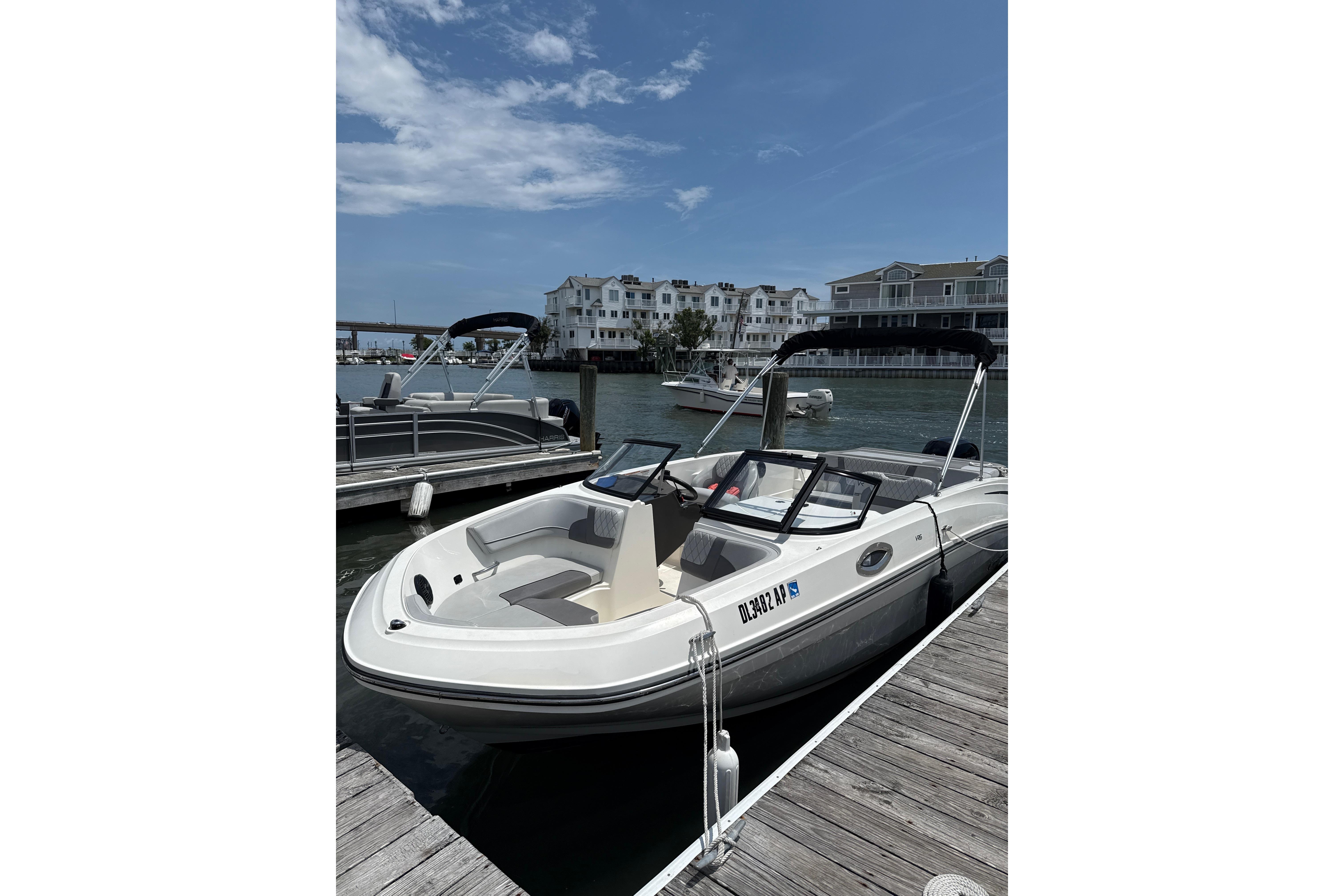 2023 Bayliner VR6 Bowrider OB docked at marina under clear sky.