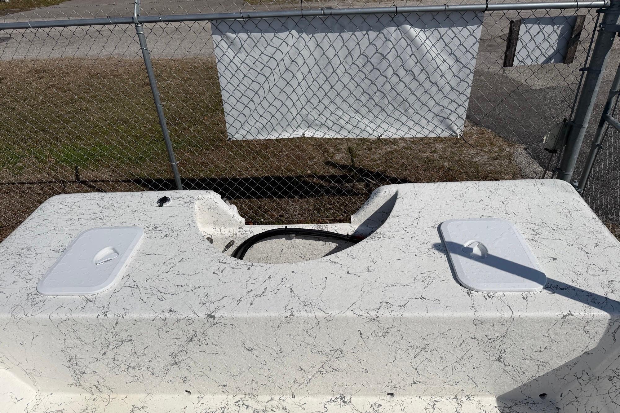 Top view of a 2027 Coastal Skiff 184 boat deck with storage compartments.
