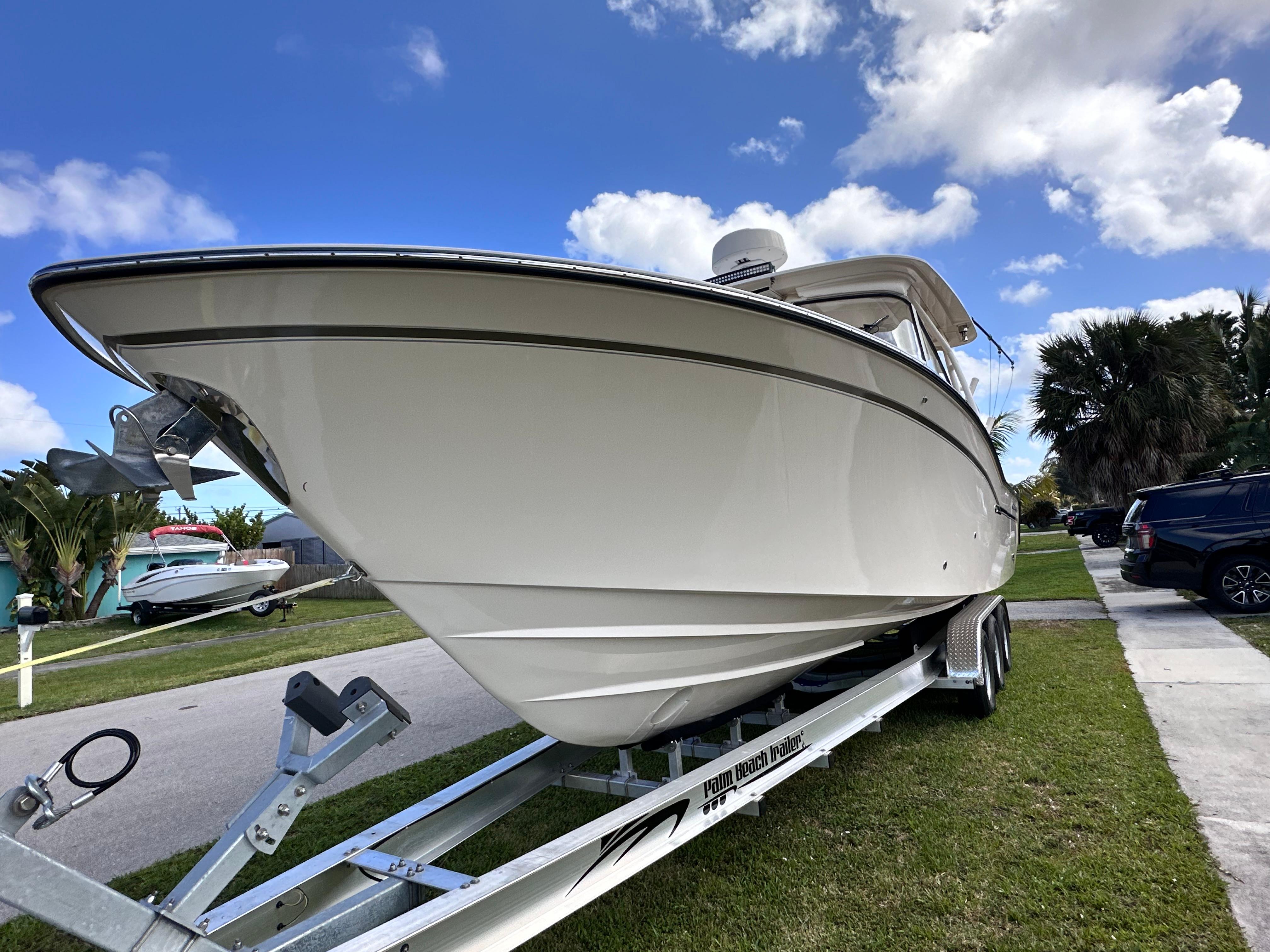 2019 Grady-White Freedom 325 boat on trailer, parked on grass under a blue sky.