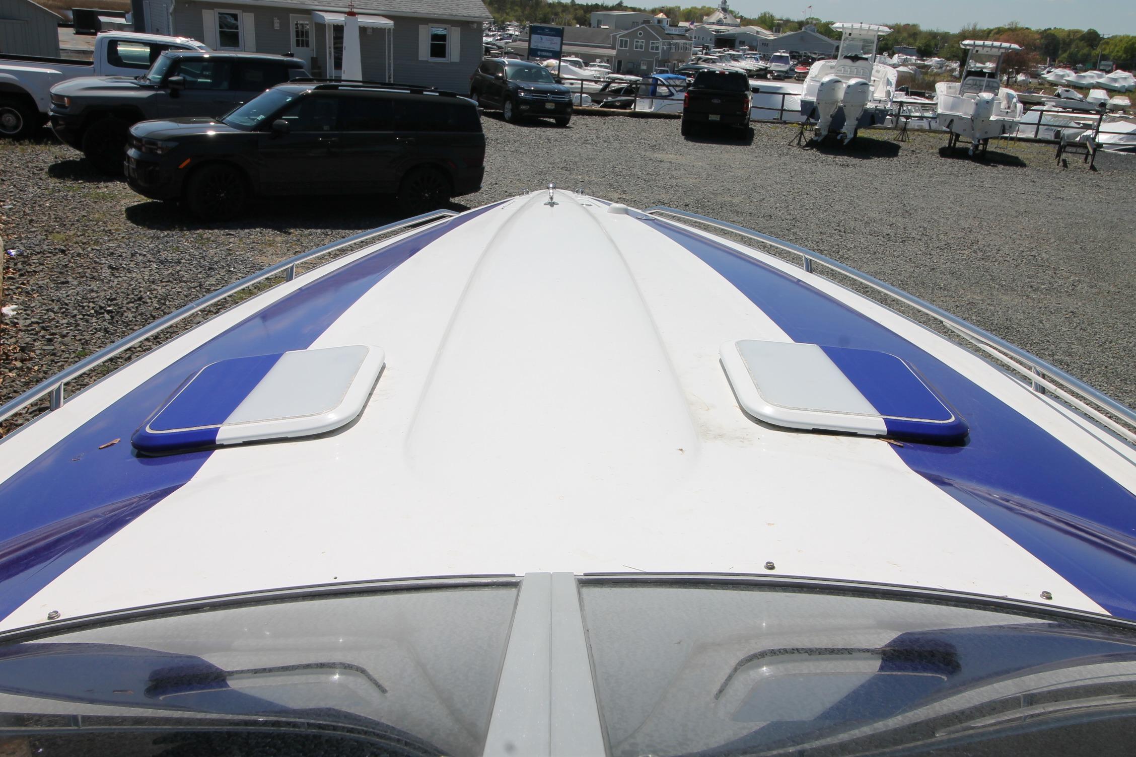 2006 Formula 292 FASTech boat with blue and white deck, parked in a marina.